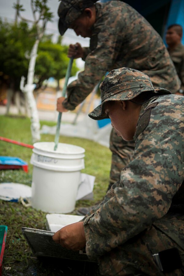Guatemalan Brigada de Infanteria de Marina (BIM) engineers mix paint in order to help remodel the Biblioteca Municipal Corporacion 74-78. The BIM engineers along with their U.S. counterparts help renovate the local library as part of a humanitarian engineering project in Puerto Barrios, Guatemala, Aug. 14, 2014. The Marines and Sailors are helping to remodel buildings in support of Southern Partnership Station 2014, a combined joint exercise focused on subject matter expert exchanges with partner nations and security forces as well as military to military engagements and community relations projects in Central America. (U.S.  Marine Corps photo by Lance Cpl. Chloe Nelson, 2D MAR DIV Combat Camera/ Released)