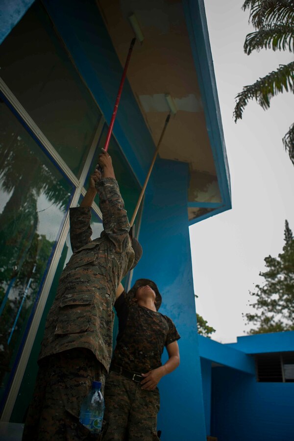 Guatemalan Brigada de Infanteria de Marina (BIM) engineers paint the exterior walls in order to help remodel the Biblioteca Municipal Corporacion 74-78. The BIM engineers along with their U.S. counterparts help renovate the local library as part of a humanitarian engineering project in Puerto Barrios, Guatemala, Aug. 14, 2014. The Marines and Sailors are helping to remodel buildings in support of Southern Partnership Station 2014, a combined joint exercise focused on subject matter expert exchanges with partner nations and security forces as well as military to military engagements and community relations projects in Central America. (U.S.  Marine Corps photo by Lance Cpl. Chloe Nelson, 2D MAR DIV Combat Camera/ Released)