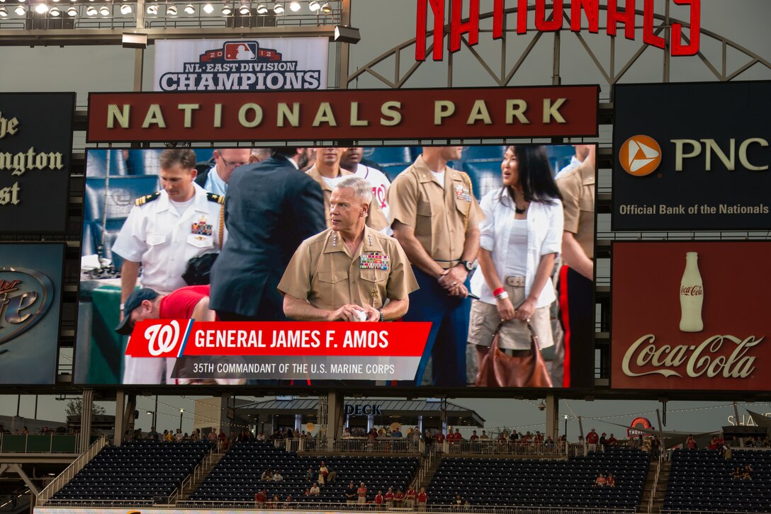 General James Amos, the commandant of the Marine Corps, is shown on the big screen as he prepares to throw the opening pitch of the Washington Nationals Marine Corps Day game against the Arizona Diamondbacks at Nationals Park in Washington, D.C., August 20, 2014. Marines lined the foul lines to watch their commandant and to salute the flag during the national anthem played by the Marine Corps Base Quantico Band.