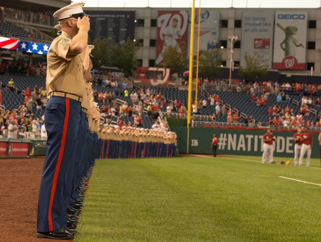 Marines salute the flag during the national anthem at the Washington Nationals game against the Arizona Diamond backs at Nationals Park on August 20, 2014. General James Amos, the commandant of the Marine Corps, threw the first pitch of the game.