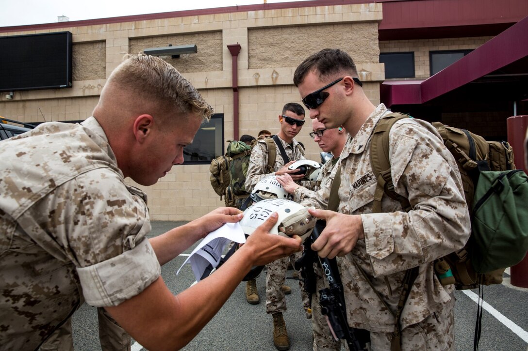 Lance Cpl. Dustin D. Glover, left, hands out radio headsets to Marines during a movement to Marine Corps Mountain Warfare Training Center from Marine Corps Air Station Camp Pendleton, Calif., on Aug. 19, 2014. These Marines will participate in Mountain Exercise at MCMWTC aboard Bridgeport, Calif.  Glover, 21, is from Elizabethon, Tennessee, assigned to Combat Logistics Battalion 15. (U.S. Marine Corps photo by Sgt. Emmanuel Ramos/Released)
