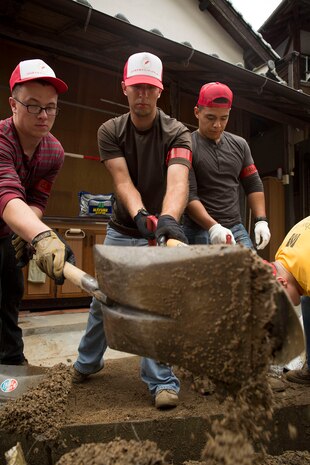 From left to right: Lance Cpl. Alex Escandon, Lance Cpl. Dominic Griffith, and Lance Cpl. Roberto Arellano, volunteers from Marine Corps Air Station Iwakuni, Japan, clear out a storm drain while volunteering to clean up damage done by Typhoon Halong behind a residence in Sunayamacho, Iwakuni, August 14, 2014. Typhoon Halong peaked as a Category 5 Super Typhoon, causing landslides, mudslides and heavy flooding, resulting in deaths, injuries, and damage throughout Japan.