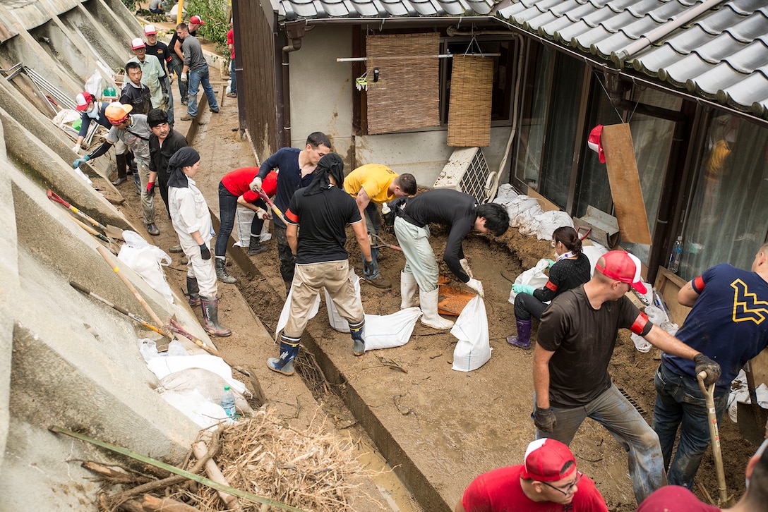 Marines from Marine Corps Air Station Iwakuni, Japan, and Japanese locals clean up damage done by Typhoon Halong behind a residence in Sunayamacho, Iwakuni, August 14, 2014. More than 30 service members volunteered to help out the local community clean up the typhoon damage.