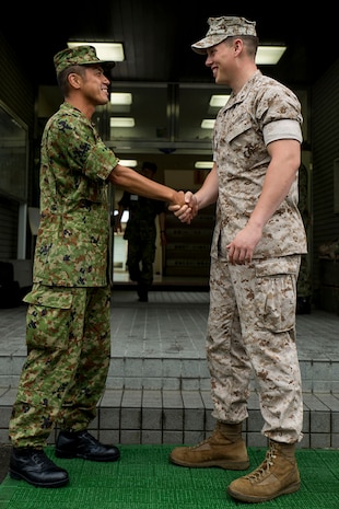 Master Sgt. Hideyuki Watabe, an infantryman with the Japan Ground Self-Defense Force’s 13th Brigade, 46th Regiment, left, and Lance Cpl. Thomas Breiter, a patrolman with the Provost Marshal’s Office aboard Marine Corps Air Station Iwakuni, Japan, shake hands at the end of an English seminar aboard JGSDF Base Kaita in Hiroshima, August 8, 2014. The purpose behind the tour was to provide Marines the opportunity to visit and experience the Japanese military lifestyle and training requisites.