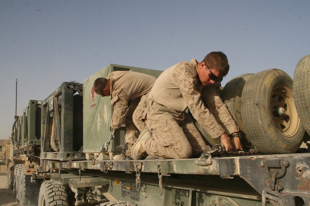 Marines with Combat Logistics Battalion 1, Regional Command, ensure chains attached to tactical gear are secure during a retrograde operation aboard Patrol Base Boldak, Helmand province, Afghanistan, Aug. 14, 2014. The operation was designed to retrograde the majority of the excess gear and equipment such as living quarters containers and air conditioning units from PB Boldak. 