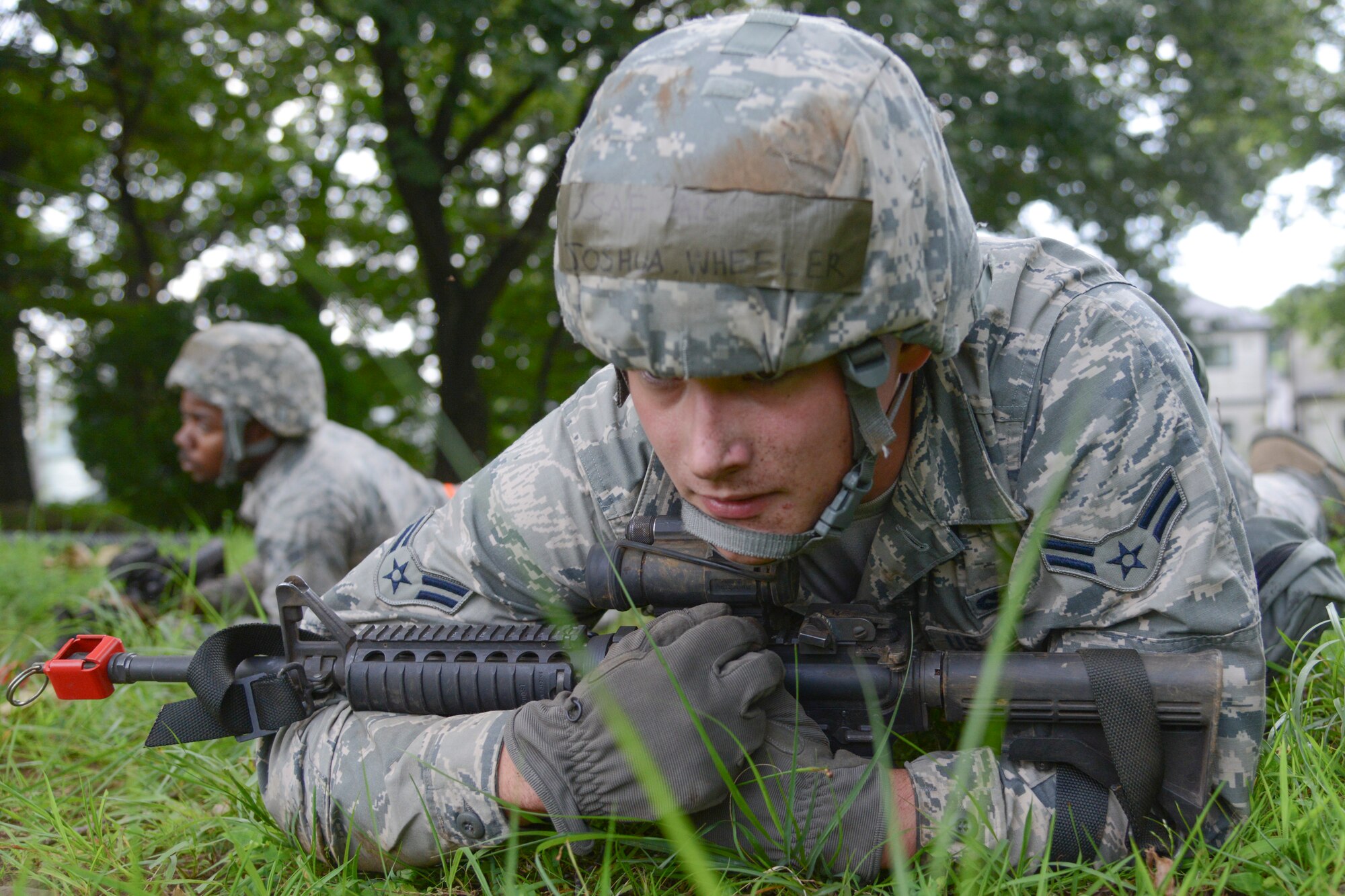 Airman 1st Class Joshua Wheeler, 374th Civil Engineer Squadron engineering technician, performs a high crawl during the 374 CES Prime Beef training day at Yokota Air Base, Japan on Aug. 21, 2014. Field training is usually done with dummy rifles called "rubber ducks", but real-steel M4s were carried by all Airmen as they performed the low crawl, high crawl and short rush. (U.S. Air Force photo by Senior Airman Michael Washburn/released)