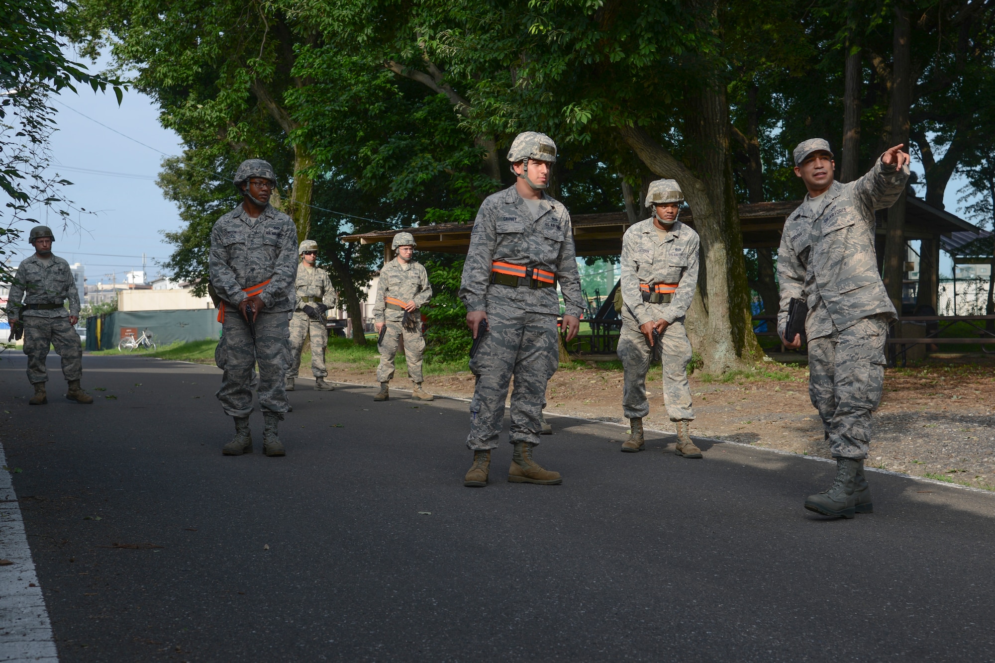 Staff Sgt. Daniel Cordova, 374th Civil Engineer Squadron movement techniques instructor, informs 374 CES Airmen about the distance they need to walk while practicing traveling techniques during the Prime Beef training day at Yokota Air Base, Japan on Aug. 21, 2014. The group practiced wedge and file formations. These formations are a way of positioning personnel or other military units. (U.S. Air Force photo by Senior Airman Michael Washburn/released)