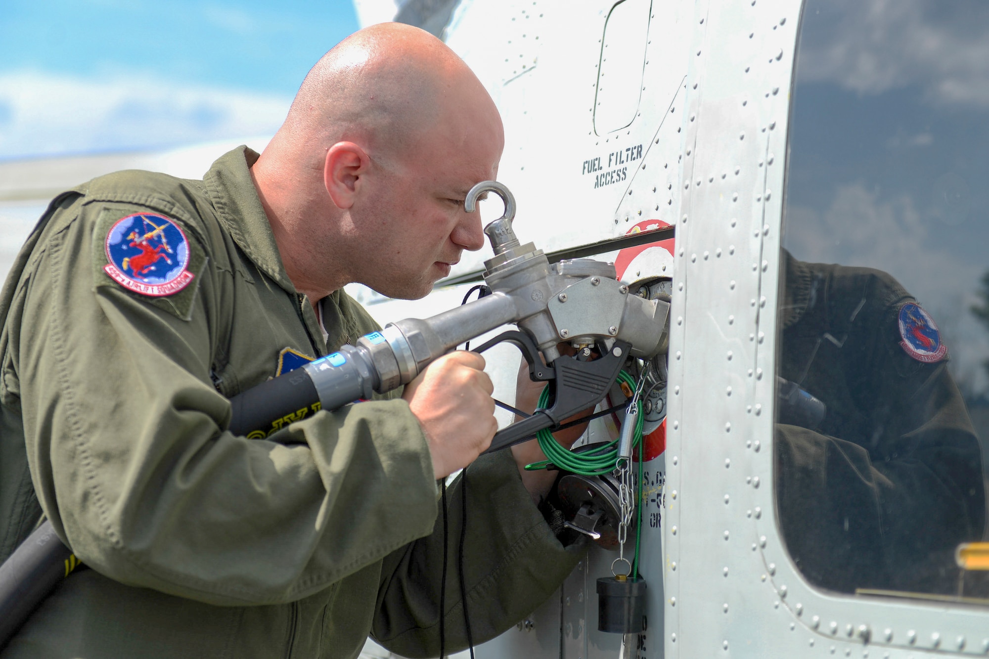 Staff Sgt. Christopher Rector, 459th Airlift Squadron flight engineer, refuels a UH-1N Iroquois during a training mission at Sendai Airport, Miyagi prefecture, Japan on Aug. 20, 2014. Airmen from the 459 AS regularly practice their airlift capabilities in order to respond to regional contingencies. (U.S. Air Force photo by Airman 1st Class Meagan Schutter/Released)