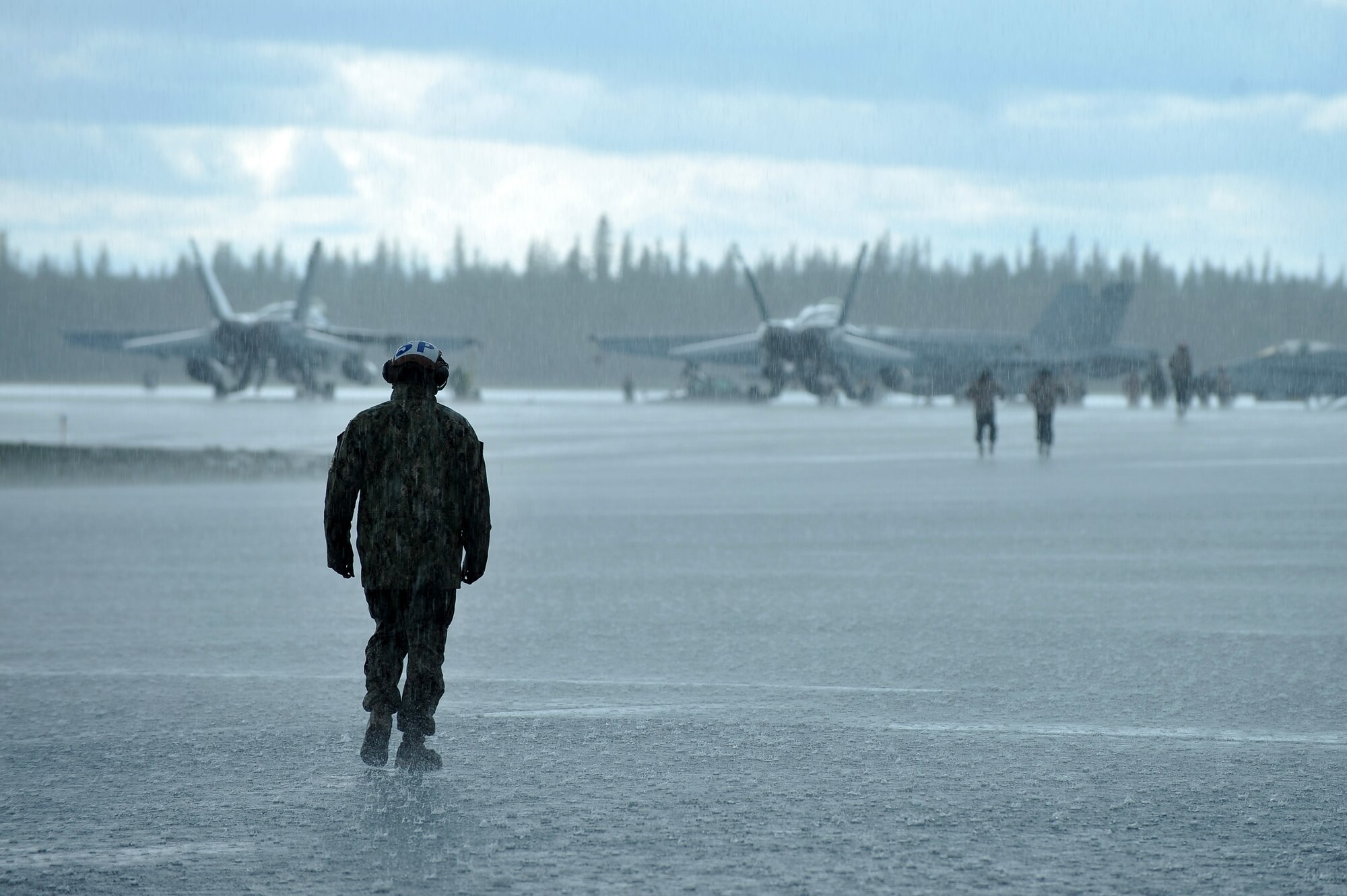 A U.S. Marine Corps maintainer assigned to the Marine Fighter Attack Squadron 323, Marine Corps Air Station Miramar, Calif., walks down the flightline during RED FLAG-Alaska 14-3 Aug. 18, 2014, Eielson Air Force Base, Alaska. RF-A is a Pacific Air Forces-directed field training exercise for U.S and allied forces to train in simulated air-combat situations. (U.S. Air Force photo by Staff Sgt. Jim Araos/Released)