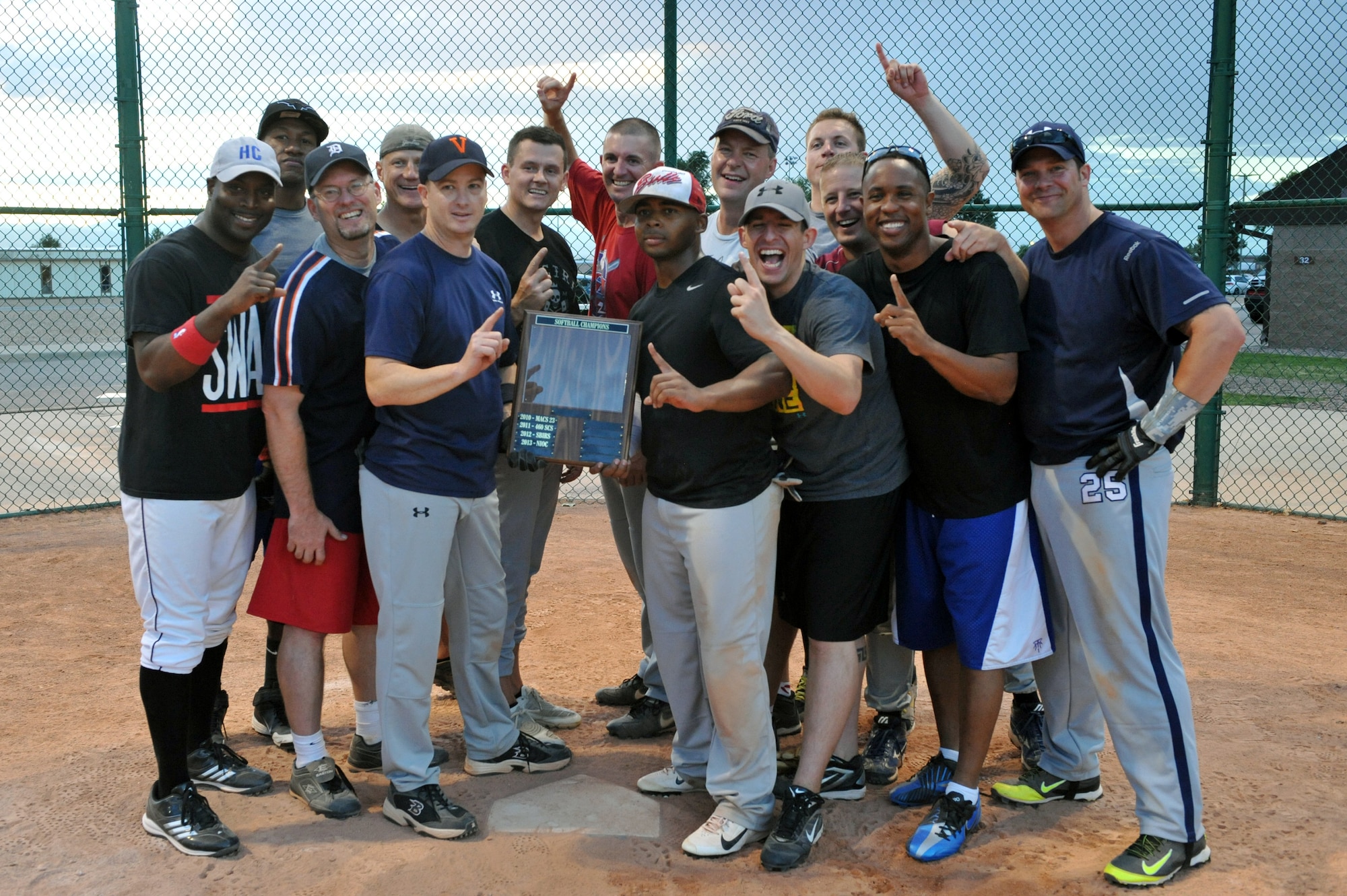 The 460th Space Wing Staff softball team poses for a celebratory photo at home plate after the championship softball game Aug. 20, 2014 at the softball fields on Buckley Air Force Base, Colo. The final score of the game was 24-9, making the wing staff team the 2014 intramural softball base champions. (U.S. Air Force photo by Airman Emily E. Amyotte/Released)