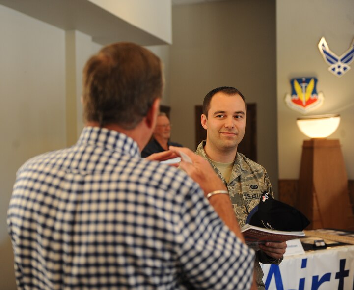 A small business owner explains the services that his company can provide to U.S. Airman 1st Class Michael Merrell, 7th Contracting Squadron (CONs), Aug. 20, 2014, at Dyess Air Force Base, Texas. The 7th CONS invited many local businesses to participate in their Small Business Outreach Program event, which is designed to explain the process of applying for a federal contract. (U.S. Air Force photo by Airman 1st Class Alexander Guerrero/Released)