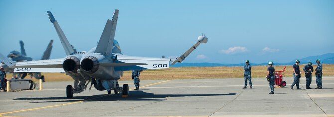 An EA- 18G Growler is prepared for take-off by Navy maintenance personnel before a flight Aug. 6, 2014, at Naval Air Station Whidbey Island, Wash. Training with different services helps accomplish real-world missions. (U.S. Air Force photo by Airman 1st Class Malissa Lott