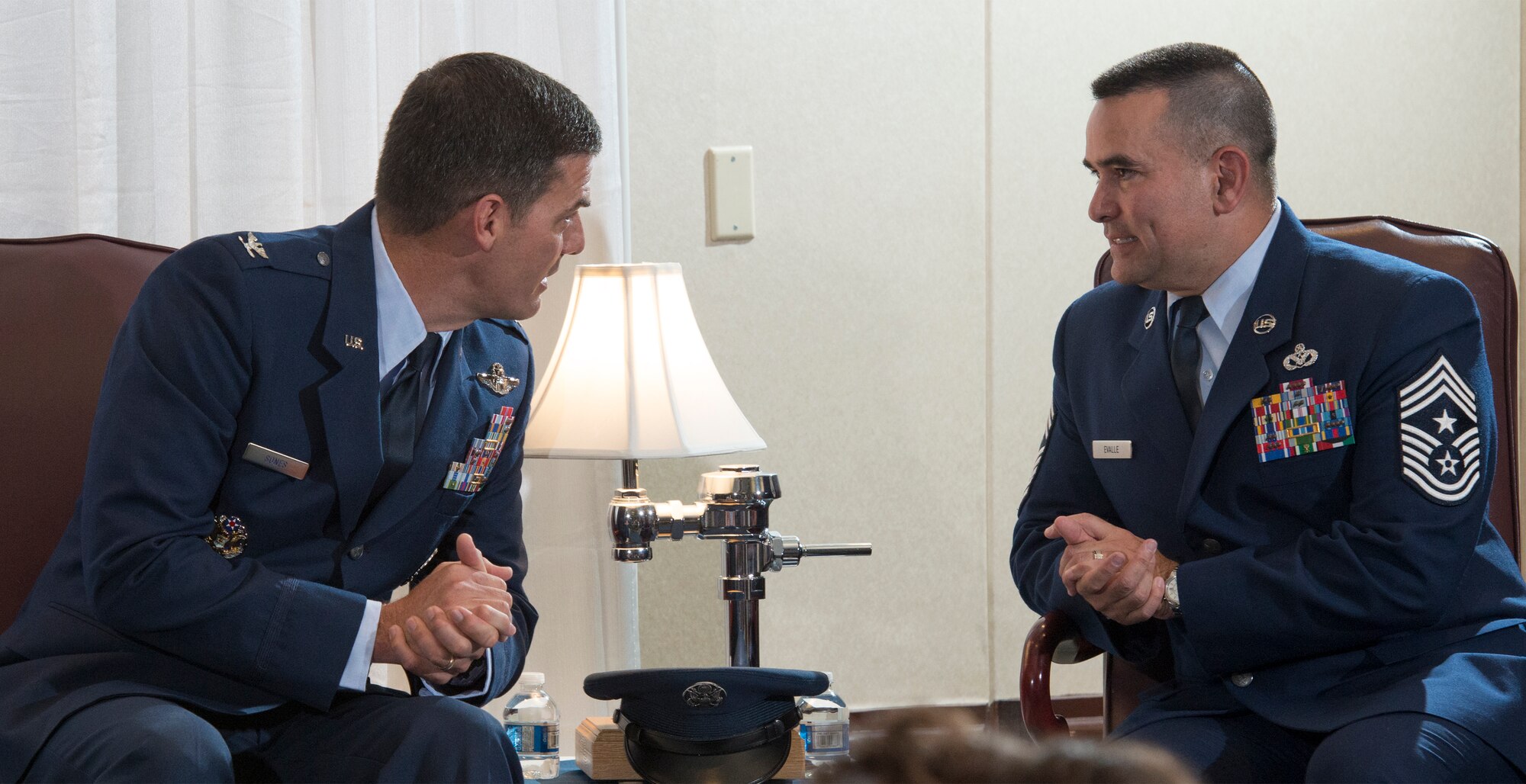 Col. Dwight Sones, left, former 60th Air Mobility Wing commander, and retired Chief Master Sgt. John Evalle, former 60th AMW command chief, talk Aug. 15 at Evalle's retirement ceremony. Sones presided over the ceremony. (U.S. Air Force photo by Heide Couch)