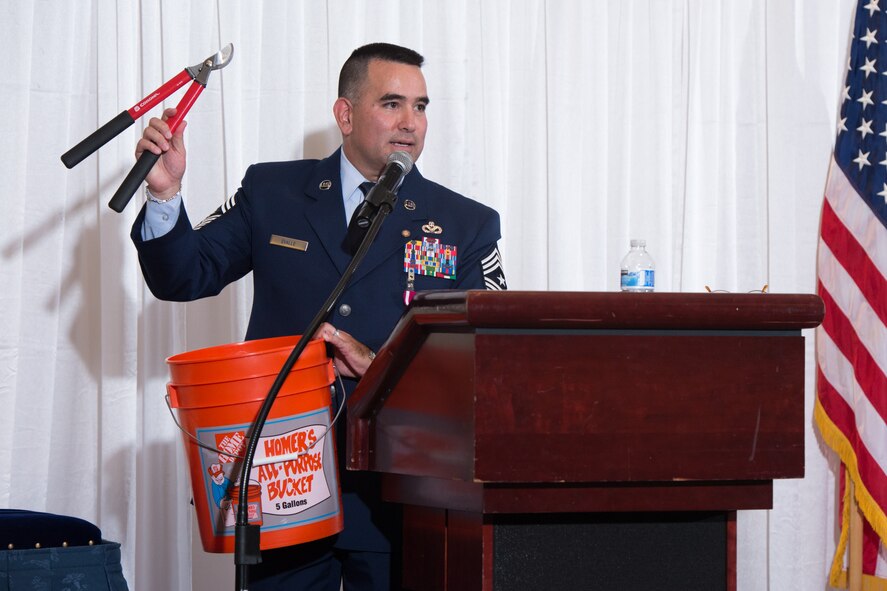 Evalle holds hedge clippers and a bucket during his parting remarks. (U.S. Air Force photo by Ken Wright)