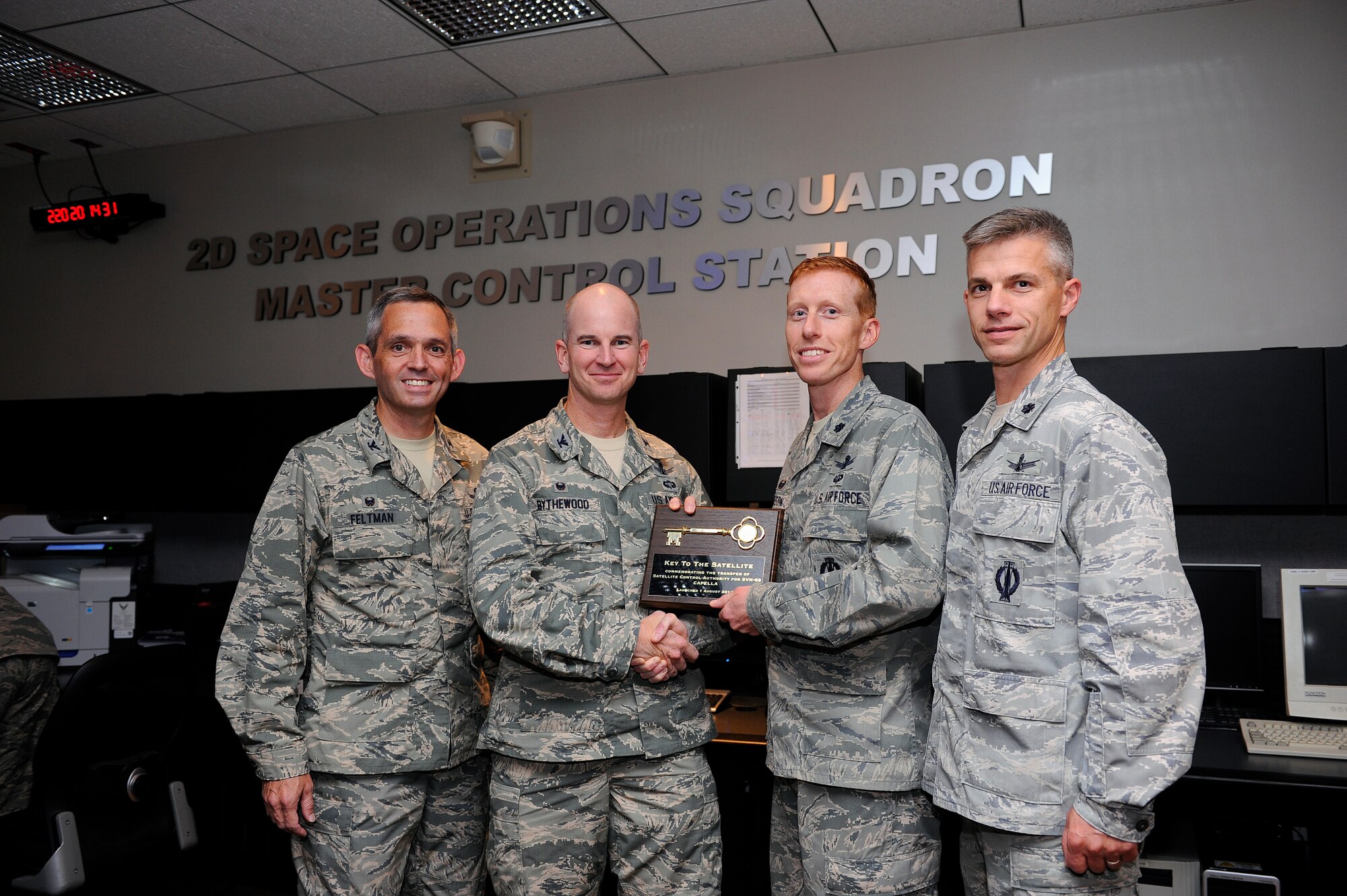 Col. Dennis Bythewood, 50th Operations Group commander, transfers command and control of the seventh GPS Block IIF satellite to Lt. Col. Todd Benson, 2nd Space Operations Squadron commander, Aug. 8 at Schriever Air Force Base, Colorado.  Col. Damon Feltman, 310th Space Wing commander (left), and Lt. Col. Stephen Slade, 19th Space Operations Squadron commander (right), also participated in the transfer ceremony.  Members of 2 SOPS and 19 SOPS operate the GPS constellation.  