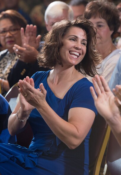 Retired Chief Master Sgt. John Evalle's wife applauds Aug. 15 during her husband's retirement ceremony. (U.S. Air Force photo by Ken Wright)
