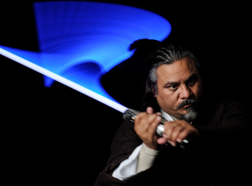 Randy Sena,11th Wing/Joint Base Andrews chief of exercises, wields his lightsaber while dressed in a Jedi costume he made himself.  And avid cosplayer, Sena has won several awards for his designs. (U.S. Air Force photo/Staff Sgt. Rob Cloys)