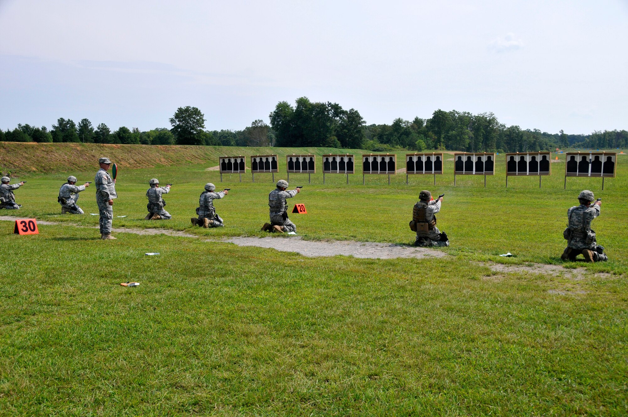 Members of the Tennessee Army and Air National Guard practice their shooting skills in the kneeling position with a Beretta M9 service pistol during a training session at the 2014 Tennessee Adjutant General Marksmanship Pistol Match in Tullahoma, TN on Aug 16. The Tennesee TAG Match is held anually to promote marksmanship skills in the Army and Air National Guard.  (U.S. Air National Guard photo by Master Sgt. Kendra M. Owenby, 134 ARW Public Affairs)