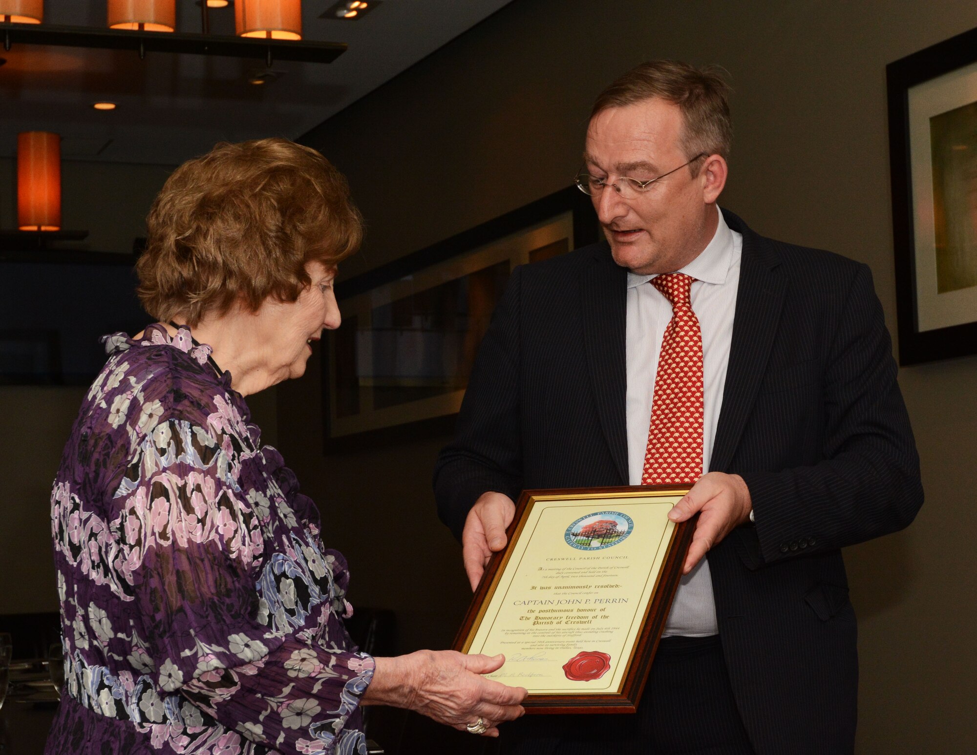 Helen Perrin, family member of Capt. John Perrin, accepts the freedom scroll from Her Britannic Majesty’s Consul-General Andrew Millar June 26, 2014, in Dallas. Perrin steered his failing aircraft away from the populated areas of Stafford and Creswell, England, resulting in the loss of his life. (Photo by Staff Sgt. Samantha Mathison)