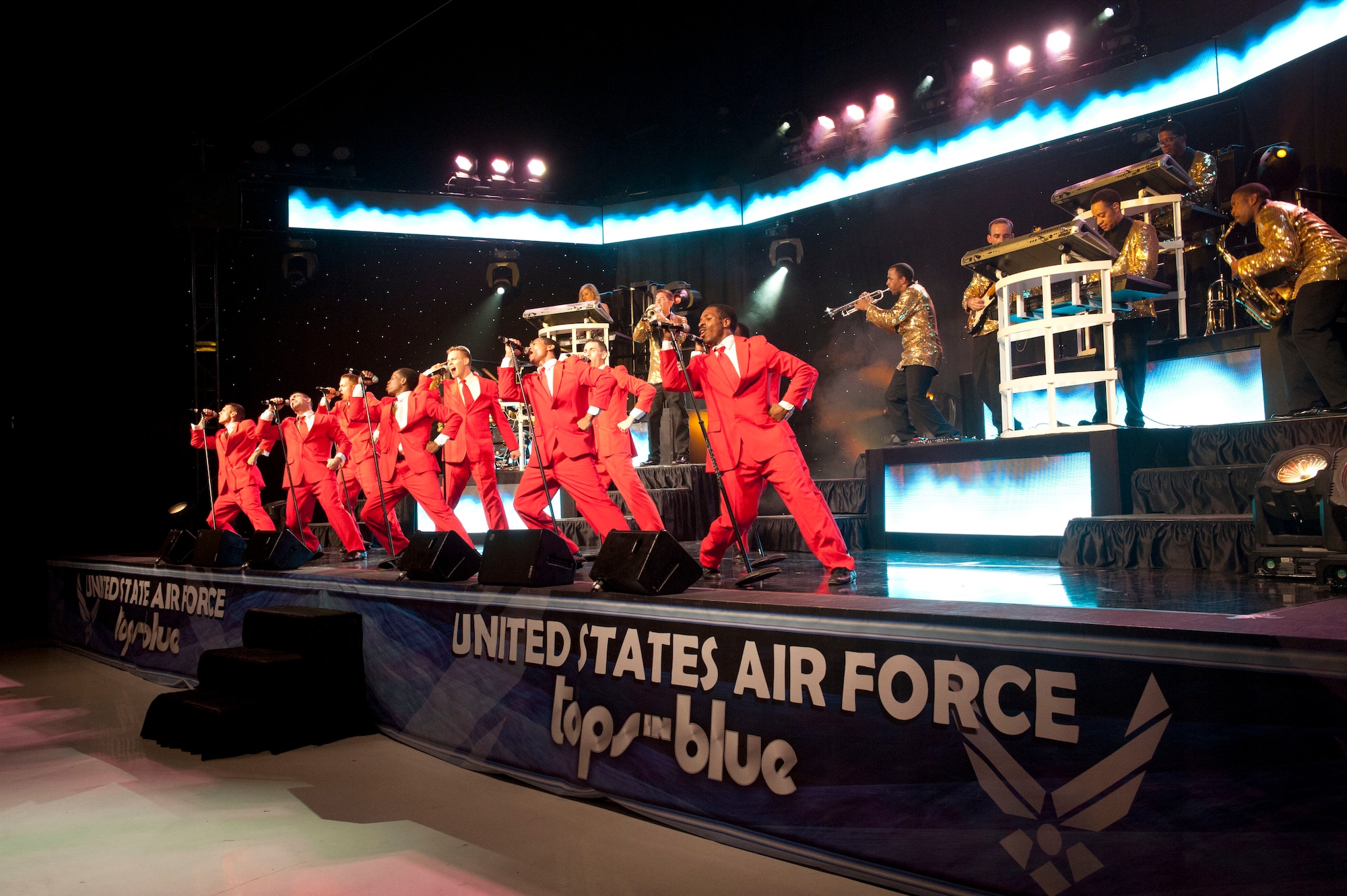 The men of U.S. Air Force Tops in Blue sing together during their performance Aug. 19, 2014, at the Wings Over the Rockies Air and Space Museum in Denver. Tops in Blue is the Air Force’s premier entertainment showcase that tours around the world, performing in 20 countries and more than 70 locations in the United States each year. (U.S. Air Force photo by Airman 1st Class Samantha Saulsbury/Released)