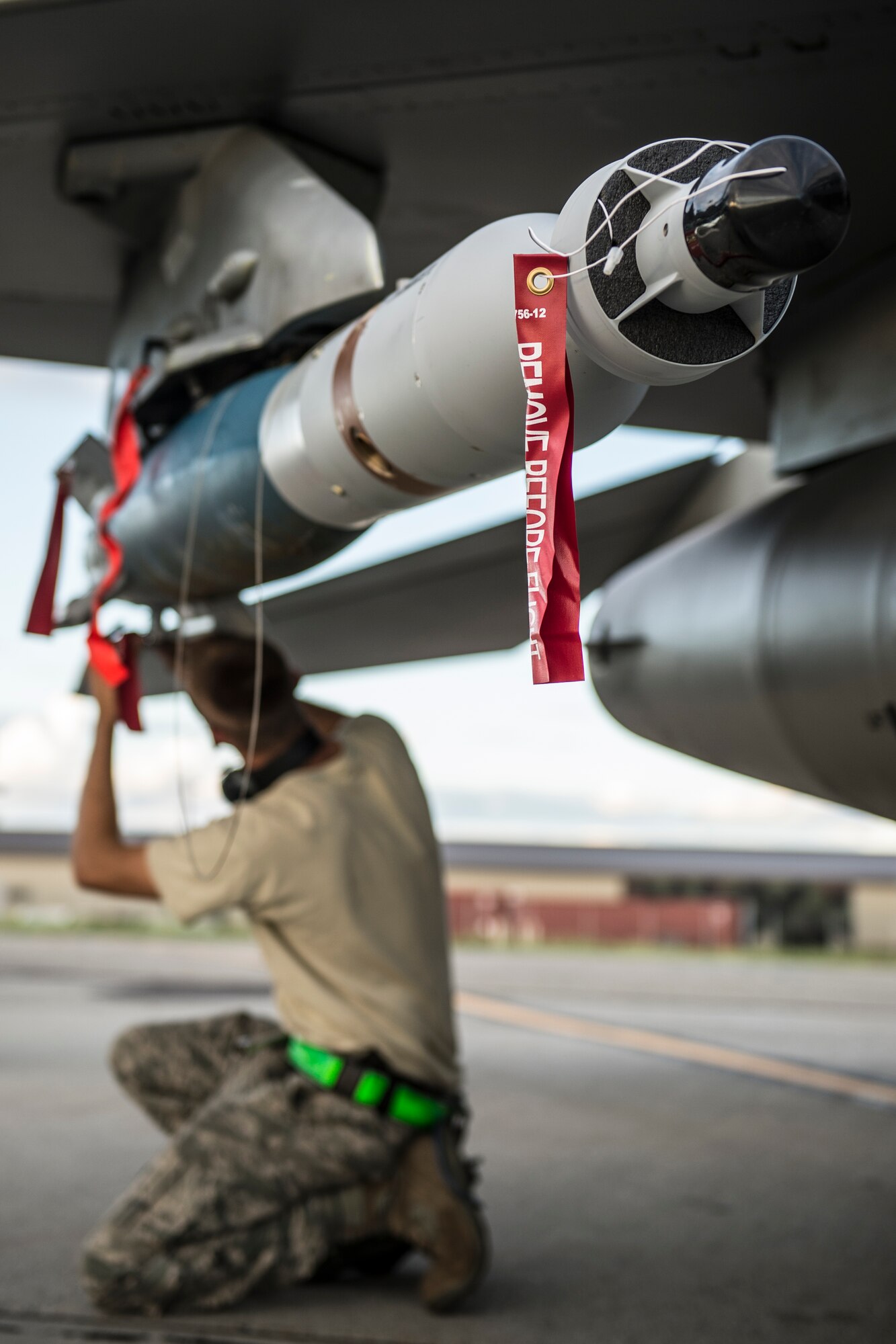 U.S. Air Force Senior Airman Benjamin O'Connor, 80th Aircraft Maintenance Unit weapons load crew member assigned to Kunsan Air Base, South Korea, attaches arming lanyards to a GBU-12 bomb  during RED FLAG-Alaska 14-3 Aug. 19, 2014, Eielson Air Force Base, Alaska. O'Connor ensured the weapons were prepared to go for the next sortie. (U.S. Air Force photo by Senior Airman Peter Reft/Released)