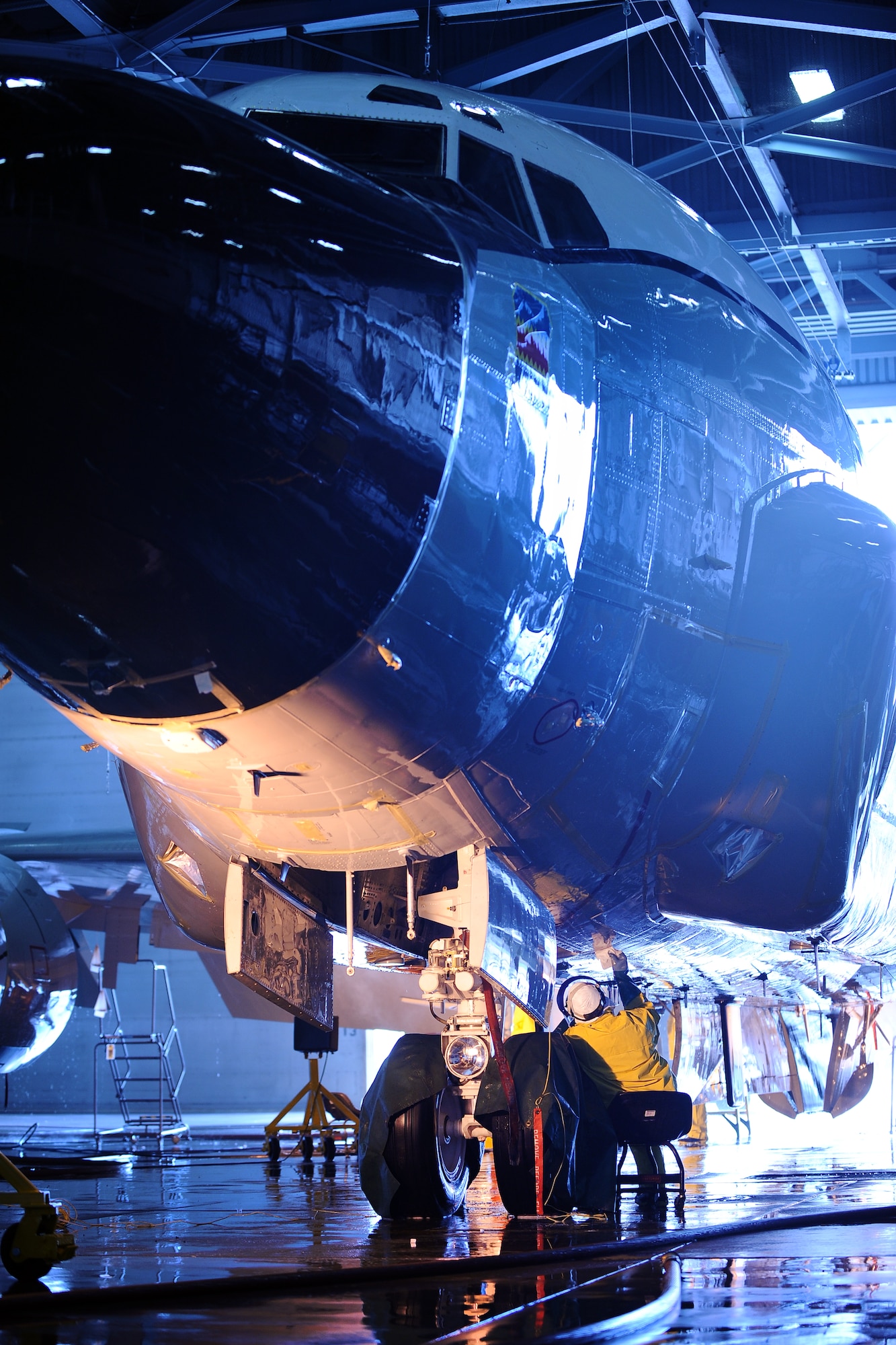 Dan Huseth, 55th Aircraft Maintenance Squadron aircraft mechanic, cleans around the front landing gear of an RC-135 V/W Rivet Joint Aug. 20 inside of the Bennie Davis Maintenance Facility, Offutt Air Force Base, Nebraska, as it undergoes a thorough cleaning. Many hours are spent detailing the reconnaissance plane as part of its regular maintenance.  (U.S. Air Force photo by Josh Plueger/Released)