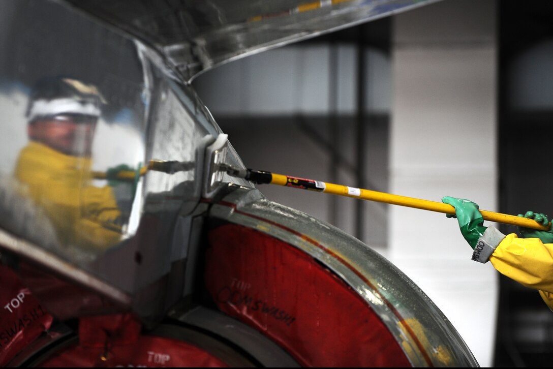 Isaac Balaun, 55th Aircraft Maintenance Squadron aircraft mechanic, washes the engine of an RC-135 V/W Rivet Joint aircraft Aug. 20 inside of the Bennie Davis Maintenance Facility, Offutt Air Force Base, Nebraska, as it undergoes a thorough cleaning.  A small team of maintainers can spend hours scrubbing and hosing the plane until it is clean.  (U.S. Air Force photo by Josh Plueger/Released)