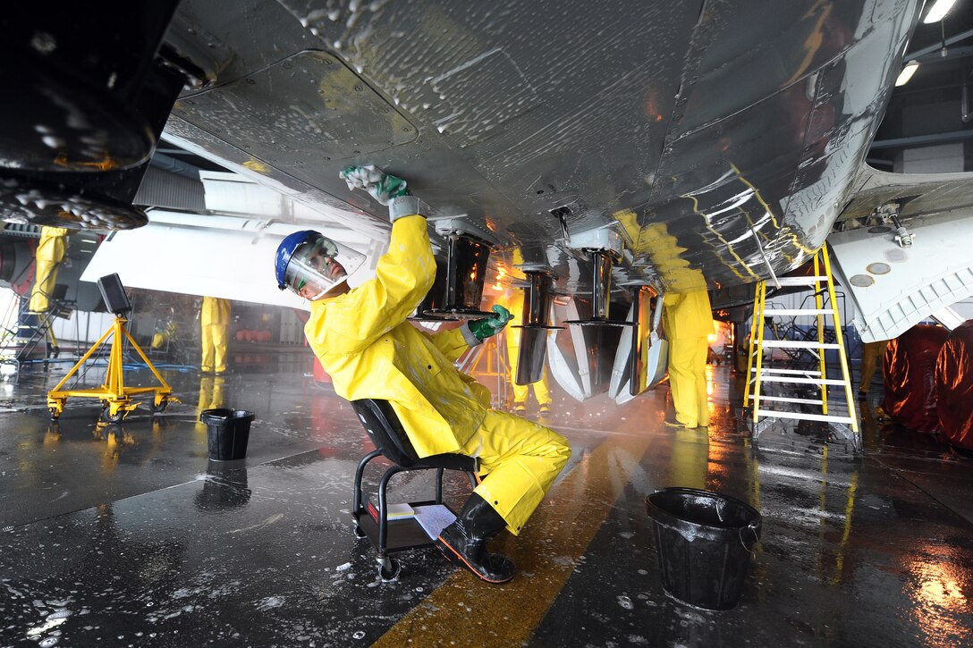U.S. Air Force Staff Sgt. Nathaniel Young, 55th Aircraft Maintenance Squadron dedicated crew chief, scrubs the bottom of an RC-135 V/W Rivet Joint aircraft Aug. 20 inside of the Bennie Davis Maintenance Facility, Offutt Air Force Base, Nebraska,  as it undergoes a thorough cleaning. Aircraft are routinely taken into the facility for extensive cleanings.  (U.S. Air Force photo by Josh Plueger/Released)