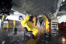 U.S. Air Force Staff Sgt. Nathaniel Young, 55th Aircraft Maintenance Squadron dedicated crew chief, scrubs the bottom of an RC-135 V/W Rivet Joint aircraft Aug. 20 inside of the Bennie Davis Maintenance Facility, Offutt Air Force Base, Nebraska,  as it undergoes a thorough cleaning. Aircraft are routinely taken into the facility for extensive cleanings.  (U.S. Air Force photo by Josh Plueger/Released)