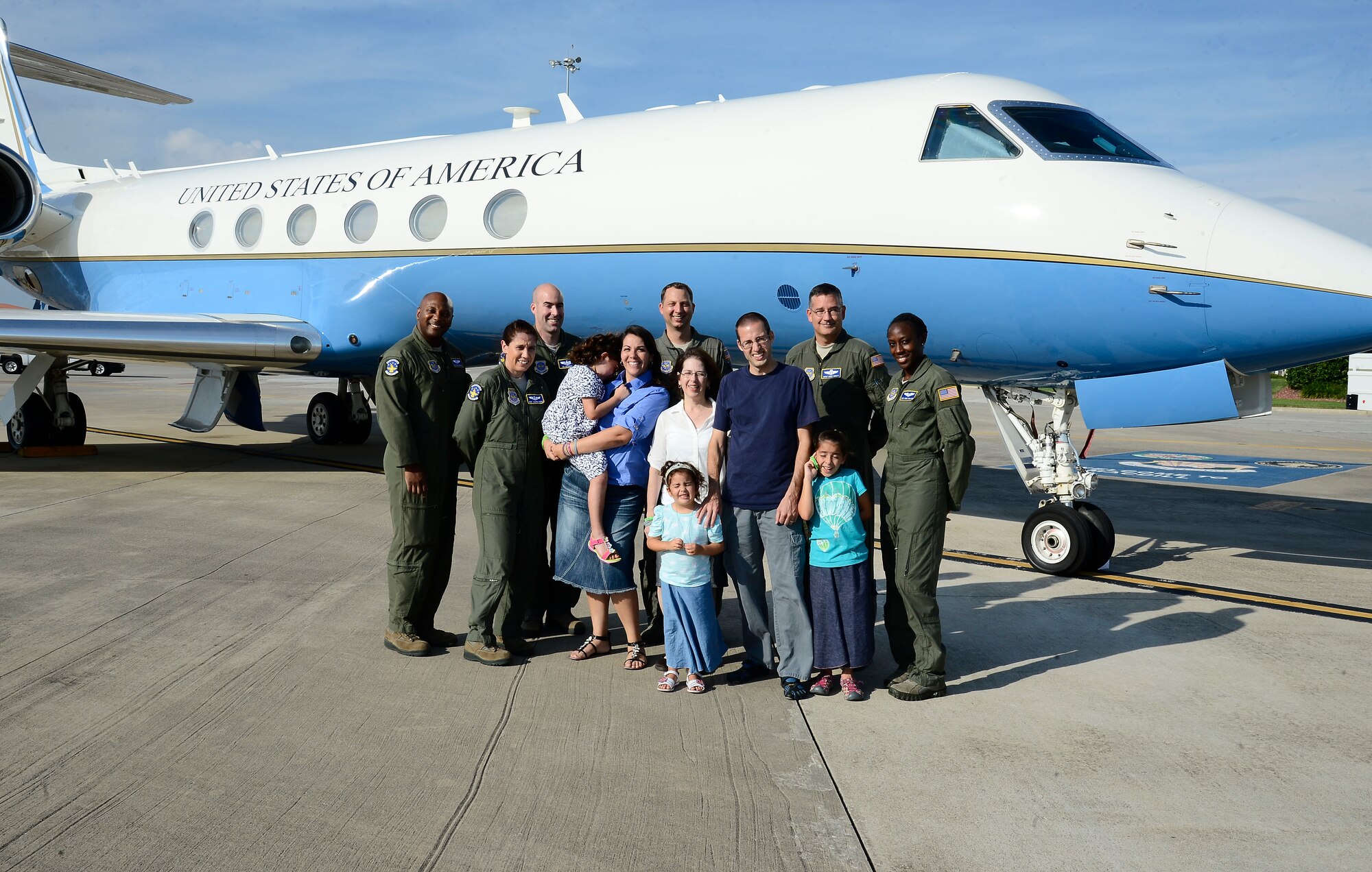 The Little family and members from the 310th airlift squadron pose for a group photo in front of a G-5 Gulfstream at MacDill Air Force Base, Fla., Aug. 1, 2014. Various units from MacDill came together to put on a special event for Molly Little, age five, daughter of Tech. Sgt. Peter Little, 6th Logistics Readiness Squadron duty title. Molly was diagnosed with an inoperable terminal tumor on her brain stem. (U.S. Air Force photo by Airman 1st Class Tori Schultz/Released)