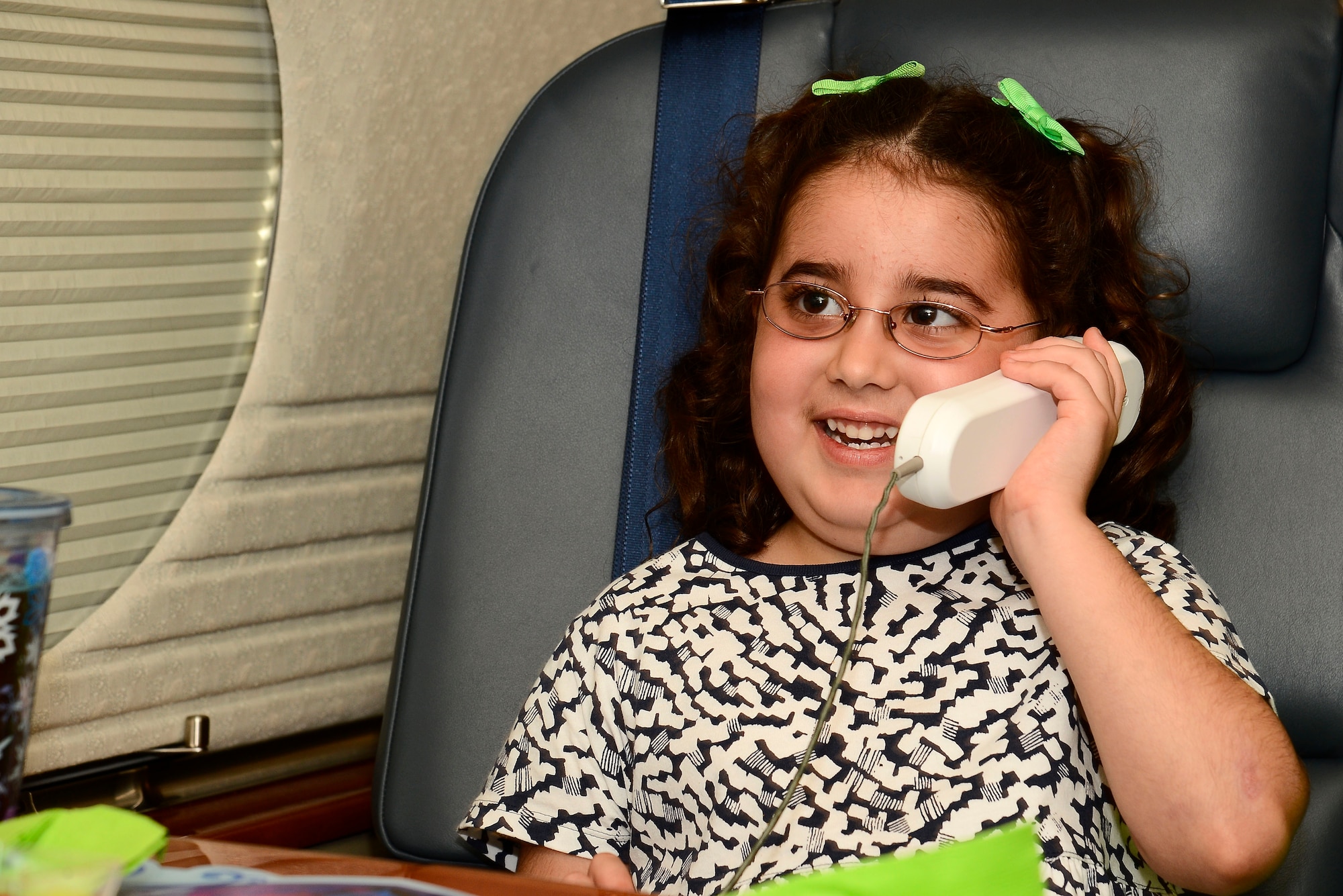 Molly Little, age five, daughter of Tech. Sgt. Peter Little, 6th Logistics Readiness Squadron NCO in-charge of air freight, calls her grandfather from a G-5 Gulfstream at MacDill Air Force Base, Fla., Aug. 1, 2014.  Molly was a distinguished visitor for an evening and got to experience what it would be like to fly with five star services. (U.S. Air Force photo by Airman 1st Class Tori Schultz/Released)