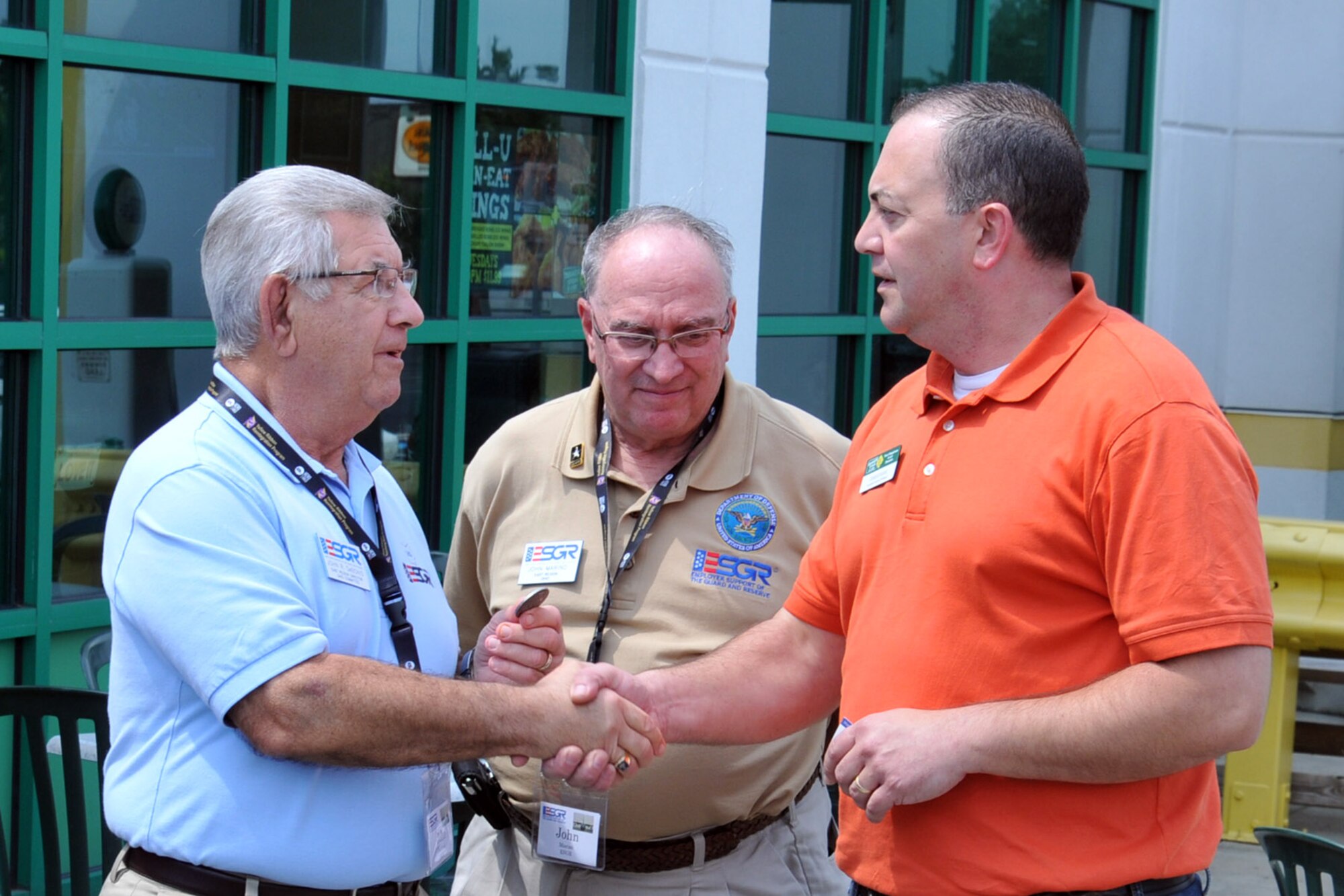 AUSTINTOWN, Ohio – Ohio Employer Support of the Guard and Reserve (ESGR) East Region Director Mr. John De Bonis presents a coin to Austintown Quaker Steak and Lube manager Todd Evans as Mr. John Marino, an Ohio ESGR military outreach coordinator looks on, during a luncheon at the restaurant here, Aug. 8, 2014. The coin was presented to Evans for hosting a group of attendees of the 2nd Annual Joint Employer Awareness Event. The two-day event, designed to give civilian employers of Air Force Reservists and Ohio National Guardsmen a better understanding of the mission their employees carry out as members of the U.S. Armed Forces, also gave attendees the opportunity to get an up-close look at military facilities at both nearby Youngstown Air Reserve Station, Ohio and Camp Ravenna, Ohio. U.S. Air Force photo by Tech. Sgt. James Brock