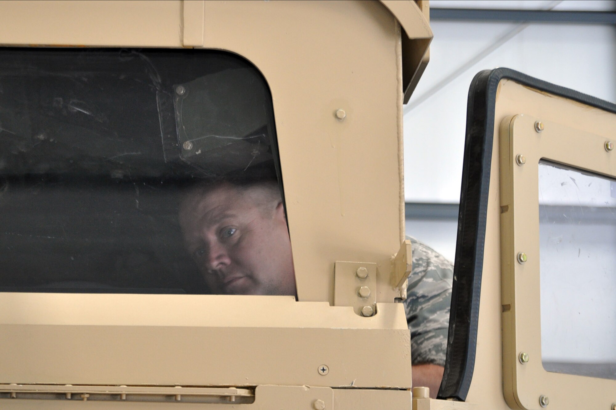 CAMP RAVENNA, Ohio – Air Force Reserve Maj. Brent Davis, 910th Airlift Wing chief of public affairs, closely inspects the interior of a Humvee roll-over simulator during the 2nd Annual Joint Employer Awareness Event here, Aug. 8, 2014. The two-day event, designed to give civilian employers of Air Force Reservists and Ohio National Guardsmen a better understanding of the mission their employees carry out as members of the U.S. Armed Forces, also gave attendees the opportunity to get an up-close look at both the 910th's facilities at nearby Youngstown Air Reserve Station, Ohio and the Ohio National Guard's Joint Military Training Center here. U.S. Air Force photo by Master Sgt. Bob Barko Jr.