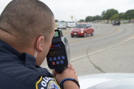Officer Marcelo Aguillon, 502nd Security Forces Logistics Support Group, uses his speed laser equipment to record vehicle speeds July 9 at Joint Base San Antonio-Randolph. (U.S. Air Force photo by Joel Martinez)
