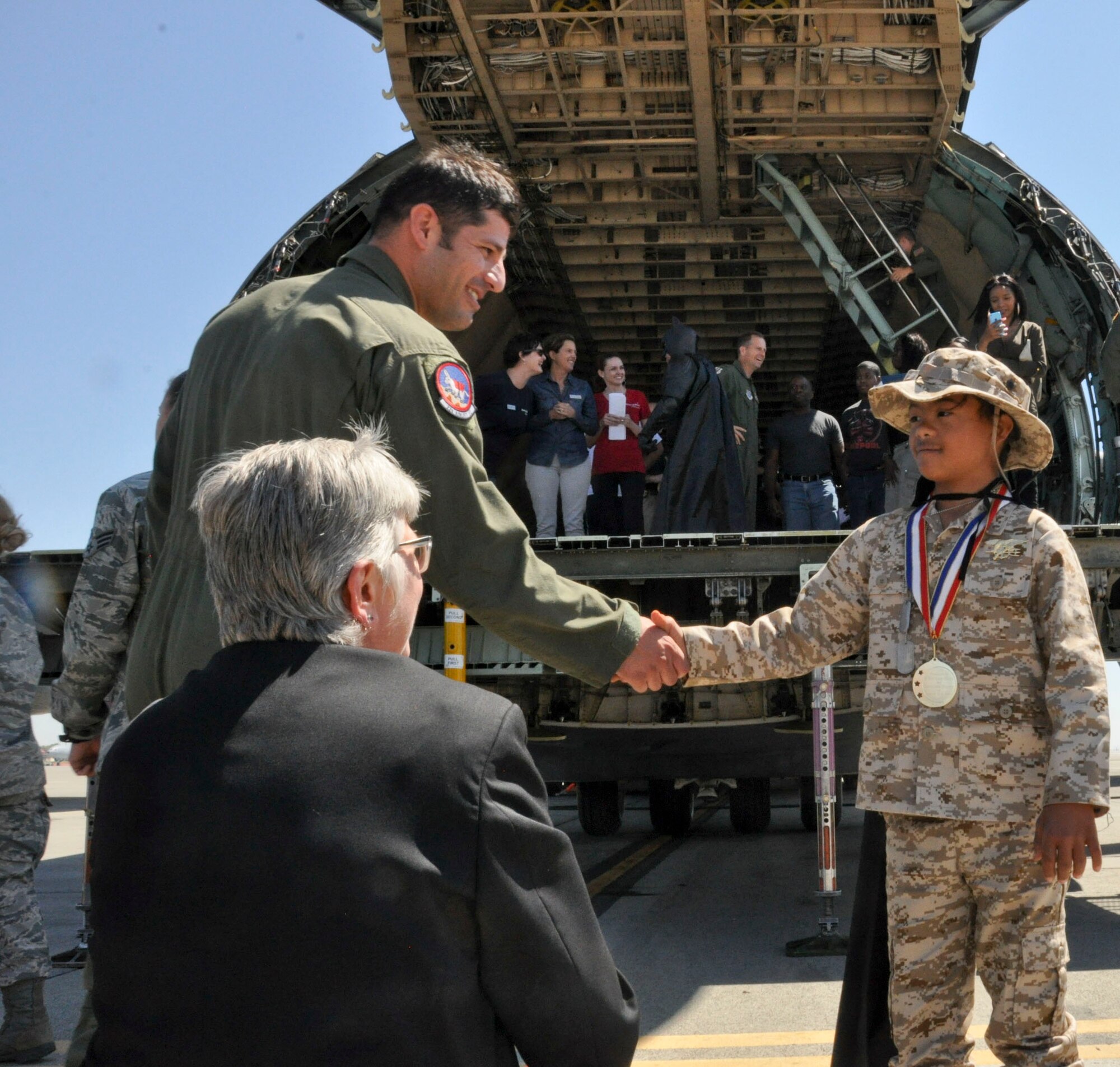 D’Marrion Otten, Make-a-Wish foundation wish recipient, meets Airmen volunteers Aug. 15 at Travis Air Force Base. Travis Airmen participated with the Coast Guard to help the Make-a-Wish Foundation grant D’Marrion’s wish to fly in a helicopter with a superhero.  (U.S. Air Force photo by Airman 1st Class Amber Carter)