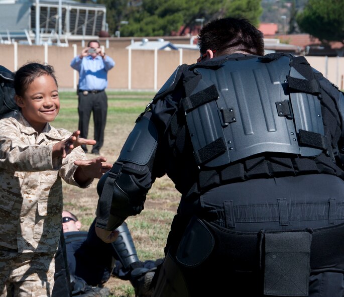 D’Marrion Otten defeats the bad guys Aug. 15 at Solano Community College. The Solano County Sheriff’s Department dressed up as bad guys and staged a rescue scenario as part of a Make-a-Wish event that also involved Travis Air Force base and the Coast Guard. (U.S. Air Force photo by Airman 1st Class Amber Carter)
