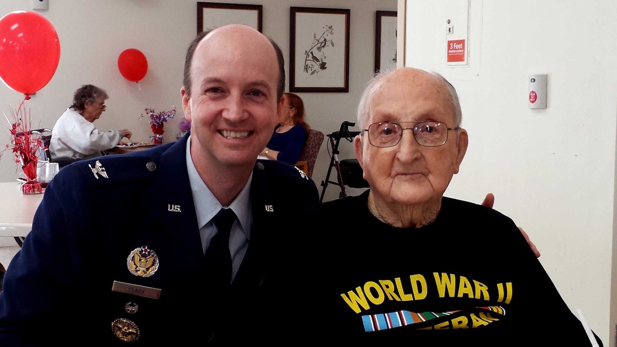 Col. Shane Clark, 30th Space Wing vice commander, spends time with World War II veteran, Carl Robertson on his 100th birthday, Aug. 14, 2014, Lompoc, California. Wing leadership and members of the base honor guard made the trip to neighboring Lompoc, to celebrate the 100th birthday of fellow brother-in-arms and World War II infantryman, Carl Robertson, at the Lompoc Comprehensive Care Center. (U.S. Air Force photo by Senior Airman Shane Phipps/Released)


