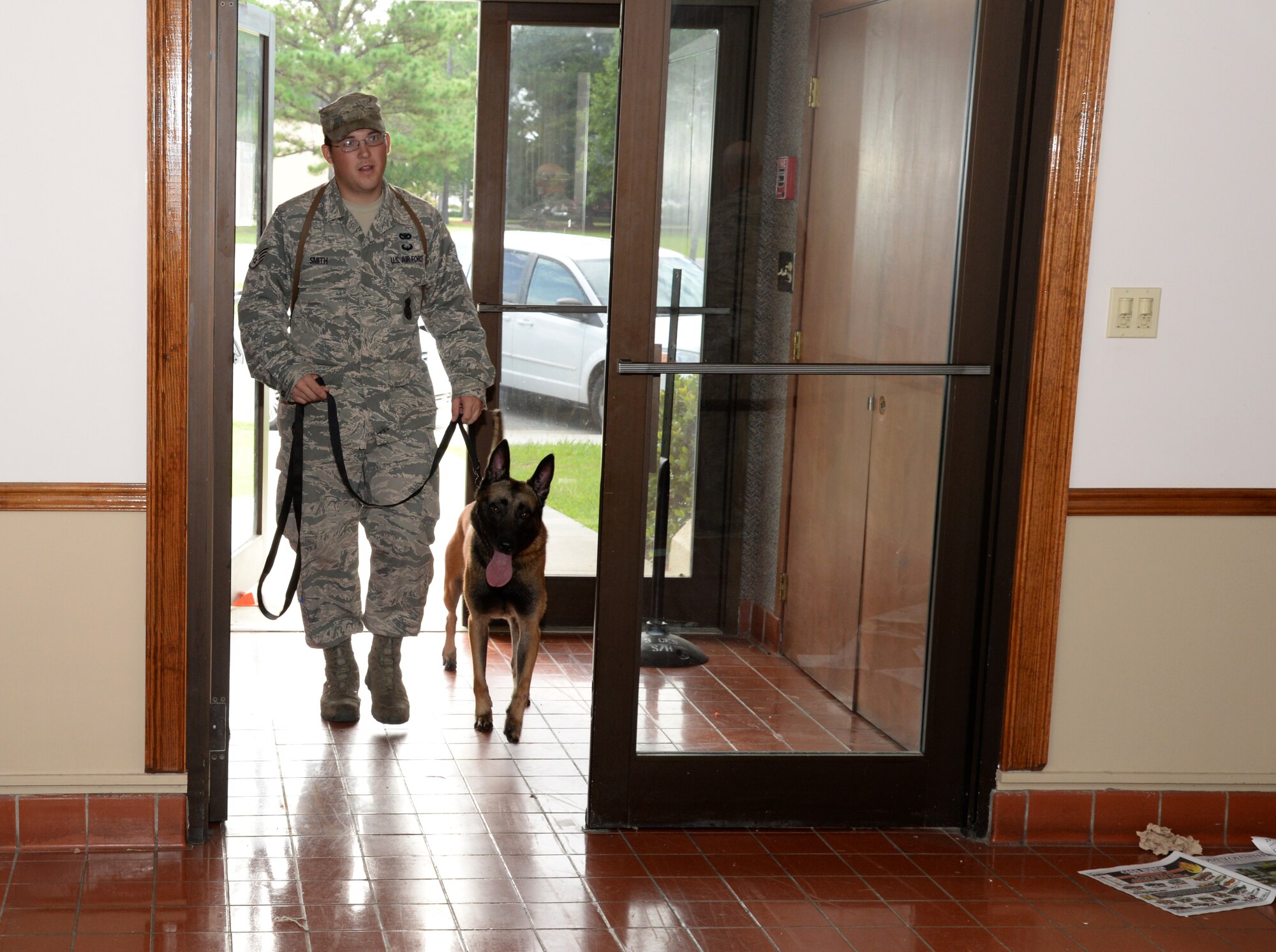 U.S. Air Force Staff Sgt. Caleb Smith, 822d Base Defense Squadron military working dog handler, begins a building search with his MWD, Celo, Aug. 20, 2014, at Moody Air Force Base, Ga. MWDs and their handlers train for various scenarios they may encounter such as bomb searching and hostile forces. (U.S. Air Force photo by Staff Sgt. Eric Summers Jr./Released)