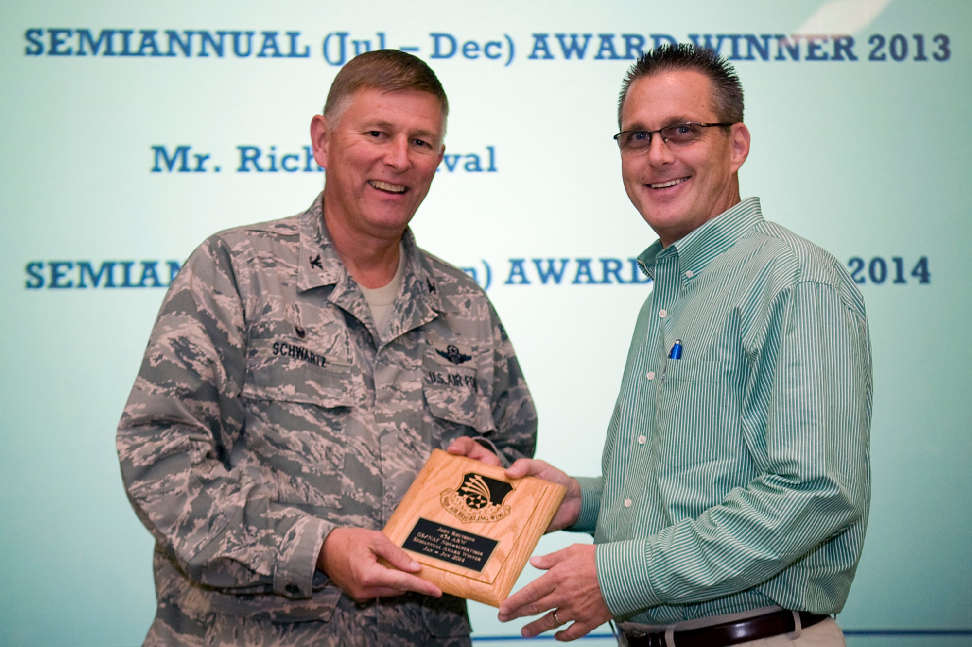 Col. Doug Schwartz, 434th Air Refueling Wing commander, left, presents Robert Moore, 434th Operations Support Squadron Airfield operations manager, with a plaque after he was named the top 434th ARW civilian for the first half of 2014 during a commander's call at Grissom Air Reserve Base, Ind., Aug. 13, 2014. Twice a year Grissom recognizes the best of the best with this award program. (U.S. Air Force photo/Tech. Sgt. Mark R. W. Orders-Woempner)
