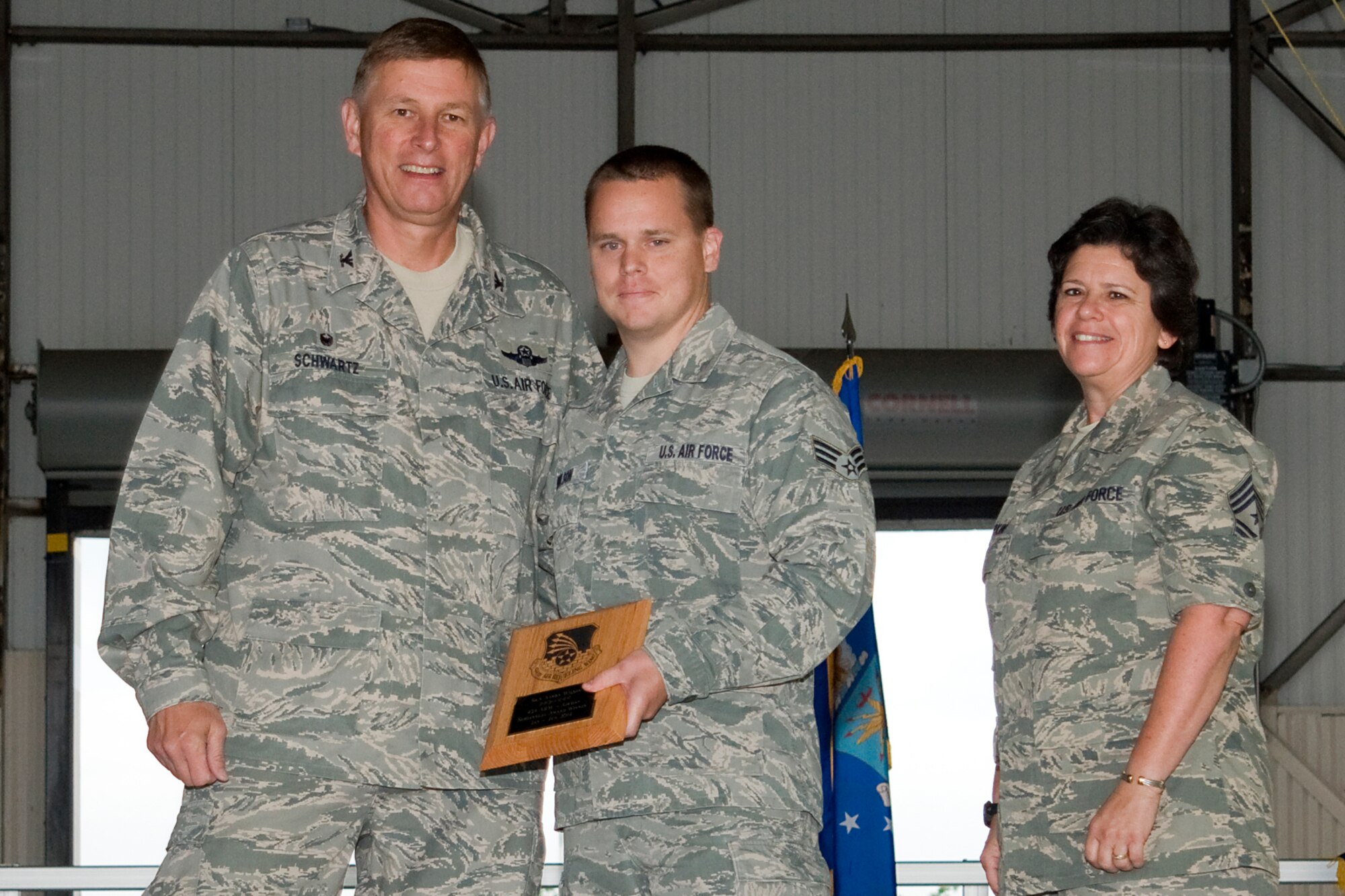 Col. Doug Schwartz, 434th Air Refueling Wing commander, left, presents Senior Airman Aaron Wilson, 434th Aerospace Medicine Squadron biomedical equipment maintenance specialist, with a plaque after he was named the top 434th ARW Airman for the first half of 2014 during a commander's call at Grissom Air Reserve Base, Ind., Aug. 10, 2014. Twice a year Grissom recognizes the best of the best with this award program. (U.S. Air Force photo/Staff. Sgt. Andrew McLaughlin)
