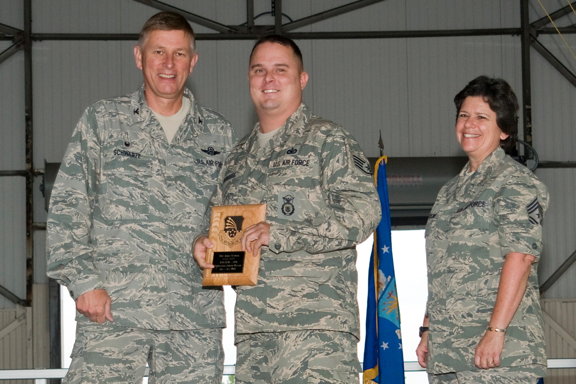 Col. Doug Schwartz, 434th Air Refueling Wing commander, left, presents Staff Sgt. Jessie Vanouse, 434th Security Forces Squadron fire team member, with a plaque after he was named the top 434th ARW noncommissioned officer for the first half of 2014 during a commander's call at Grissom Air Reserve Base, Ind., Aug. 10, 2014. Twice a year Grissom recognizes the best of the best with this award program. (U.S. Air Force photo/Staff. Sgt. Andrew McLaughlin)
