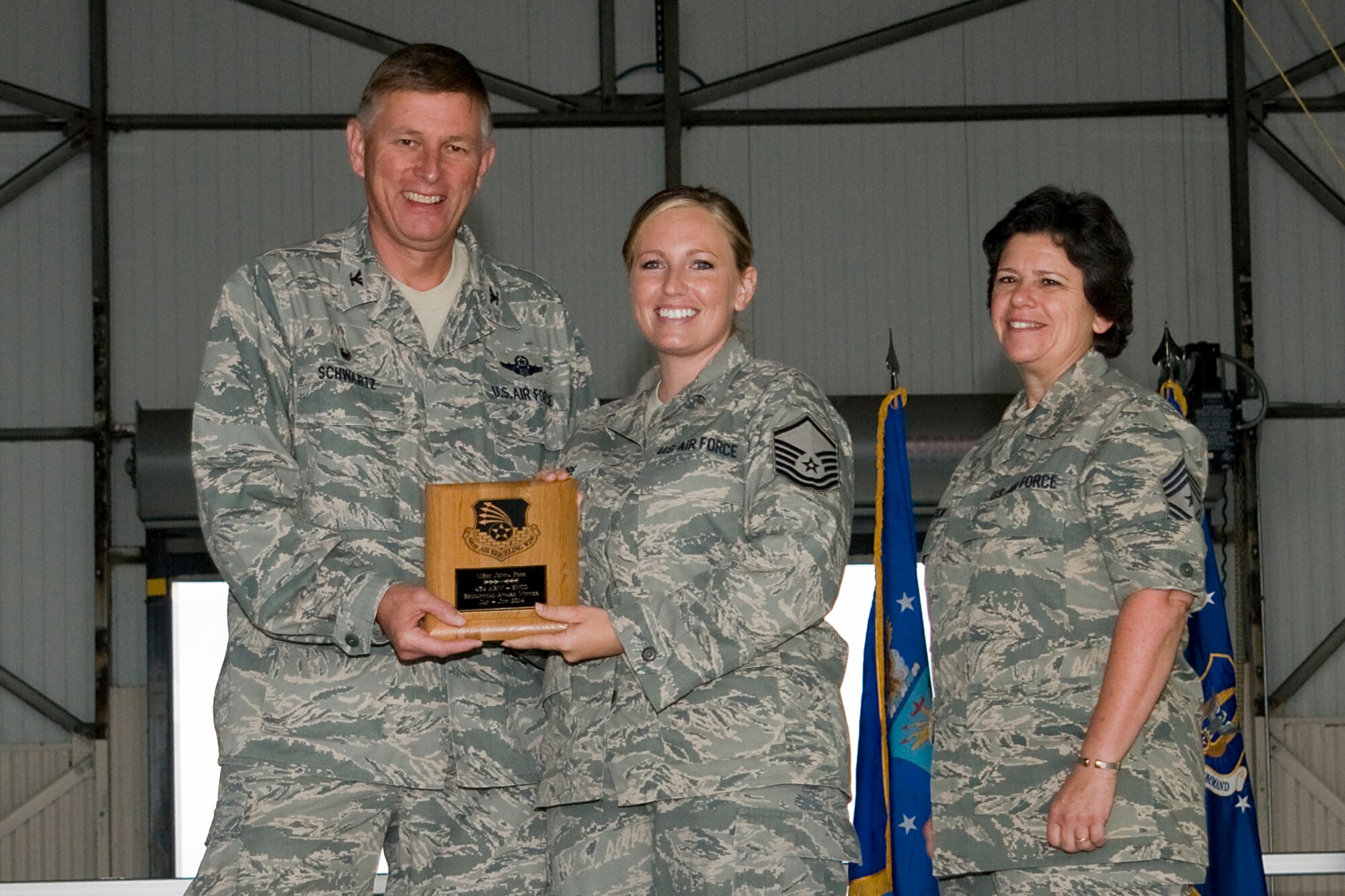 Col. Doug Schwartz, 434th Air Refueling Wing commander, left, presents Master Sgt. Jonna Sullivan, 74th Air Refueling Squadron aviation resource management technician, with a plaque after she was named the top 434th ARW Airman for the first half of 2014 during a commander's call at Grissom Air Reserve Base, Ind., Aug. 10, 2014. Twice a year Grissom recognizes the best of the best with this award program. (U.S. Air Force photo/Staff. Sgt. Andrew McLaughlin)
