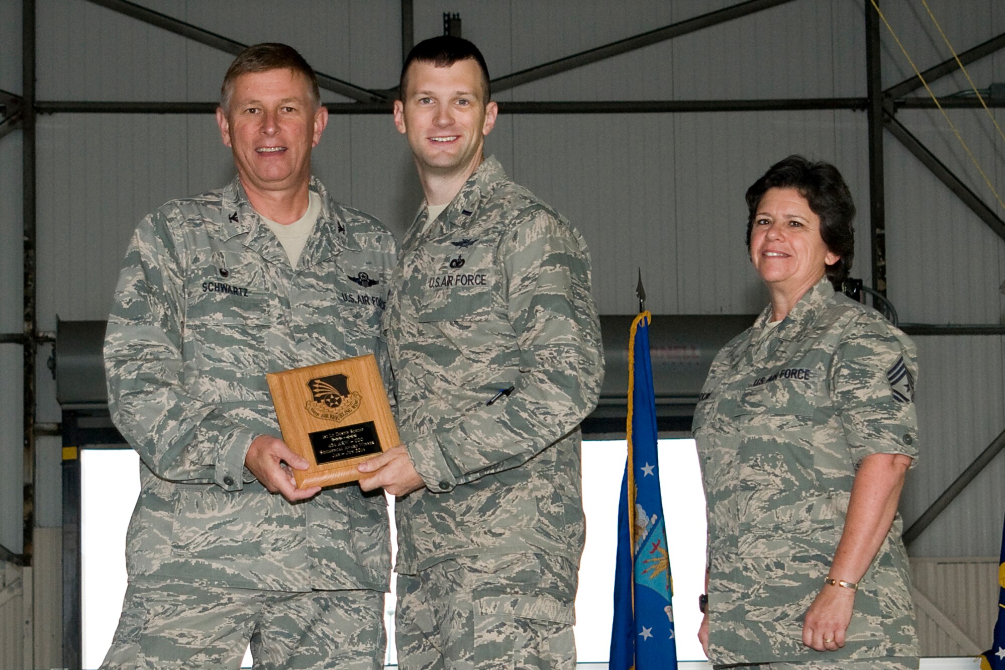 Col. Doug Schwartz, 434th Air Refueling Wing commander, left, presents 1st Lt. Dustin Schimp, 434th Communications Squadron director of operations, with a plaque after he was named the top 434th ARW company grade officer for the first half of 2014 during a commander's call at Grissom Air Reserve Base, Ind., Aug. 10, 2014. Twice a year Grissom recognizes the best of the best with this award program. (U.S. Air Force photo/Staff. Sgt. Andrew McLaughlin)
