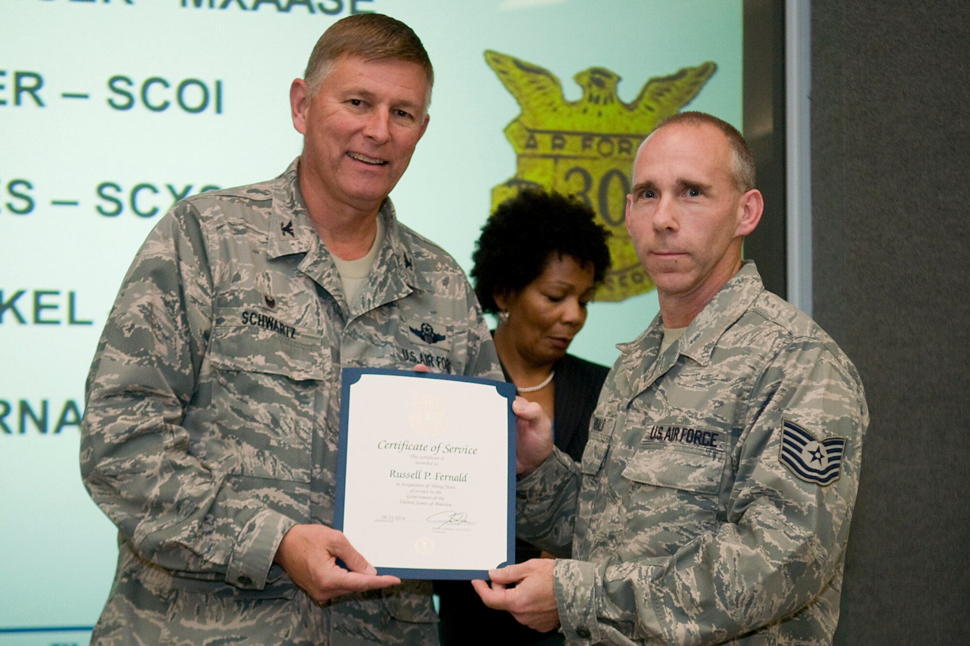 Col. Doug Schwartz, 434th Air Refueling Wing commander, presents Tech. Sgt. Russell Fernald, 434th Operations Support Squadron, with a certificate of service for completing 30 years as a federal employee during a civilian commander's call at Grissom Air Reserve Base, Ind., Aug. 13, 2014. Civil service employees are an essential part Grissom and serve critical roles in maintaining unit readiness and daily operations. (U.S. Air Force photo/Tech. Sgt. Mark R. W. Orders-Woempner)
