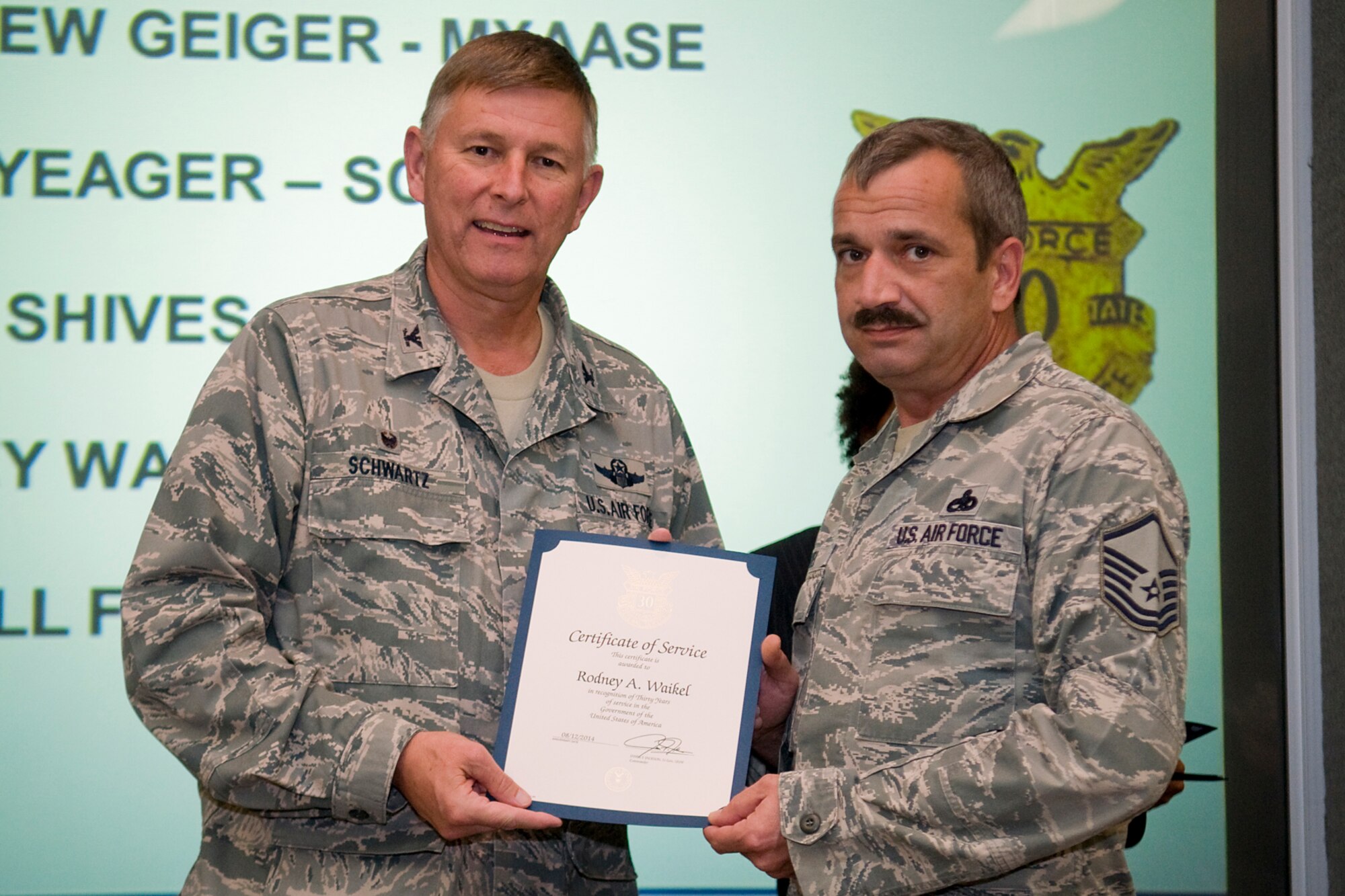 Col. Doug Schwartz, 434th Air Refueling Wing commander, presents Master Sgt. Rodney Waikel, 434th Maintenance Squadron, with a certificate of service for completing 30 years as a federal employee during a civilian commander's call at Grissom Air Reserve Base, Ind., Aug. 13, 2014. Civil service employees are an essential part Grissom and serve critical roles in maintaining unit readiness and daily operations. (U.S. Air Force photo/Tech. Sgt. Mark R. W. Orders-Woempner)
