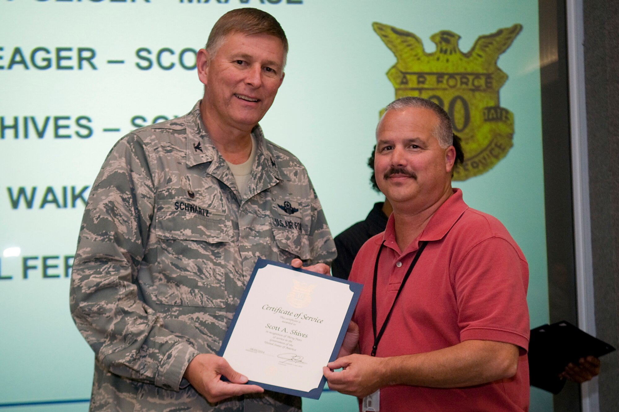 Col. Doug Schwartz, 434th Air Refueling Wing commander, presents Scott Shives, 434th Communications Squadron, with a certificate of service for completing 30 years as a federal employee during a civilian commander's call at Grissom Air Reserve Base, Ind., Aug. 13, 2014. Civil service employees are an essential part Grissom and serve critical roles in maintaining unit readiness and daily operations. (U.S. Air Force photo/Tech. Sgt. Mark R. W. Orders-Woempner)
