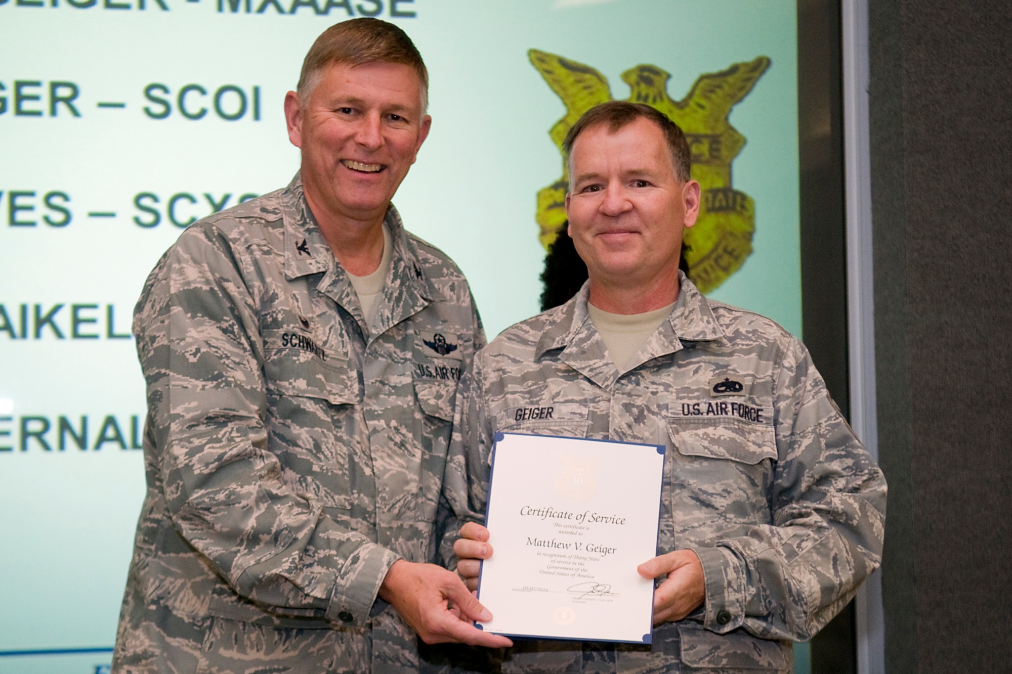 Col. Doug Schwartz, 434th Air Refueling Wing commander, presents Master Sgt. Matthew Geiger, 434th Aircraft Maintenance Squadron, with a certificate of service for completing 30 years as a federal employee during a civilian commander's call at Grissom Air Reserve Base, Ind., Aug. 13, 2014. Civil service employees are an essential part Grissom and serve critical roles in maintaining unit readiness and daily operations. (U.S. Air Force photo/Tech. Sgt. Mark R. W. Orders-Woempner)
