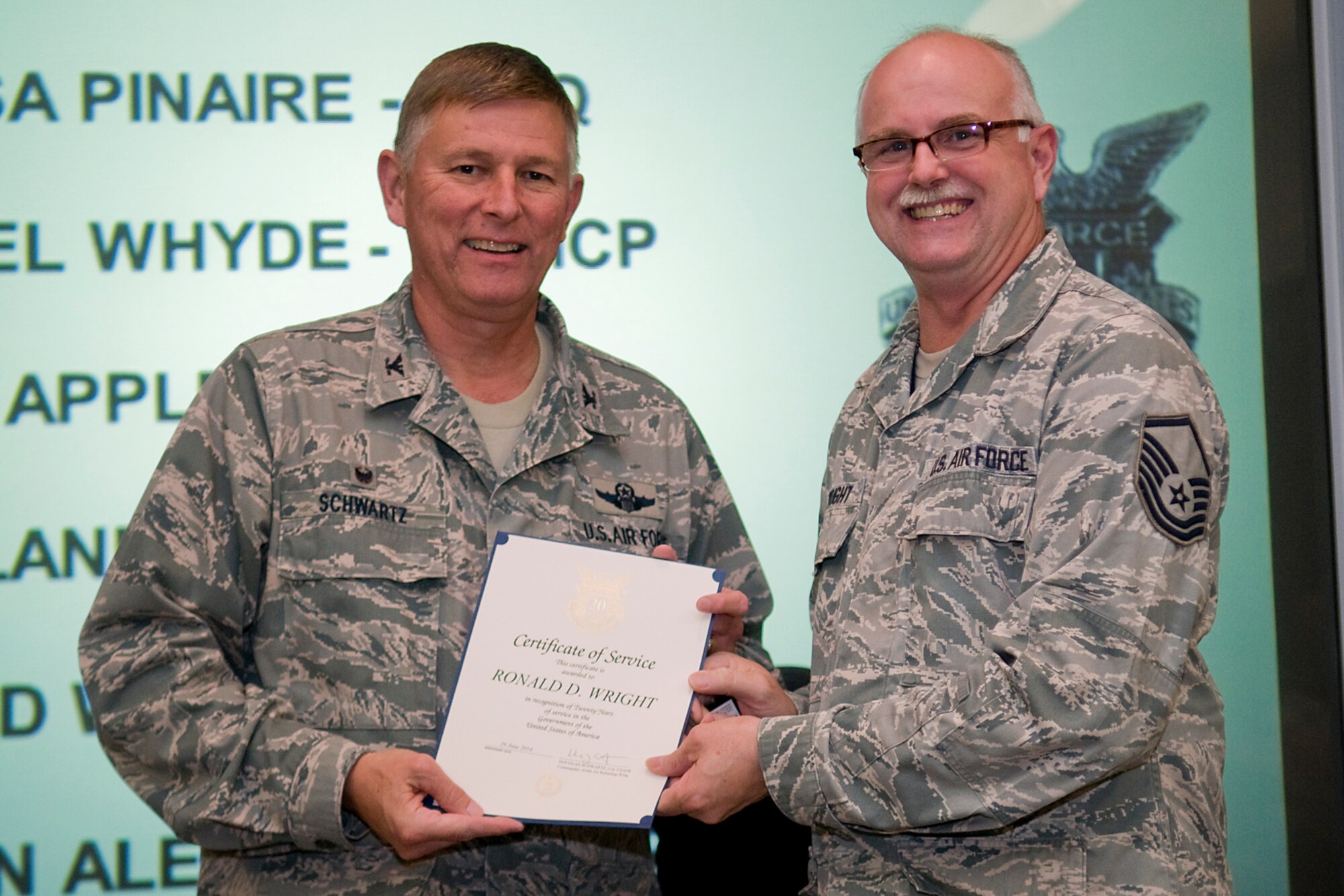 Col. Doug Schwartz, 434th Air Refueling Wing commander, presents Master Sgt. Ronald Wright, 434th Force Support Squadron, with a certificate of service for completing 30 years as a federal employee during a civilian commander's call at Grissom Air Reserve Base, Ind., Aug. 13, 2014. Civil service employees are an essential part Grissom and serve critical roles in maintaining unit readiness and daily operations. (U.S. Air Force photo/Tech. Sgt. Mark R. W. Orders-Woempner)

