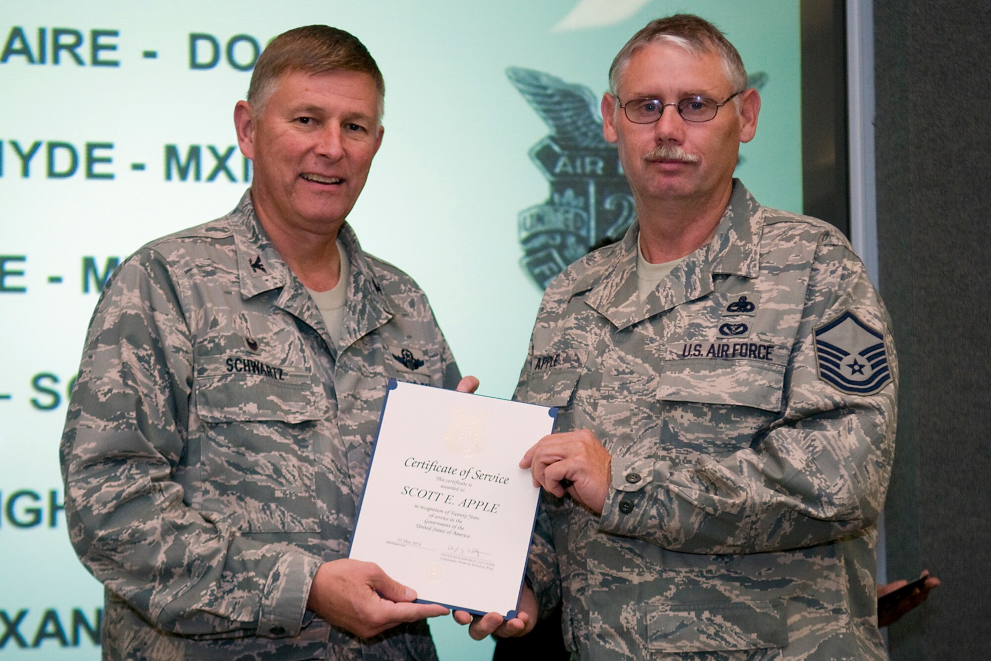 Col. Doug Schwartz, 434th Air Refueling Wing commander, presents Master Sgt. Scott Apple, 434th Maintenance Squadron, with a certificate of service for completing 20 years as a federal employee during a civilian commander's call at Grissom Air Reserve Base, Ind., Aug. 13, 2014. Civil service employees are an essential part Grissom and serve critical roles in maintaining unit readiness and daily operations. (U.S. Air Force photo/Tech. Sgt. Mark R. W. Orders-Woempner)
