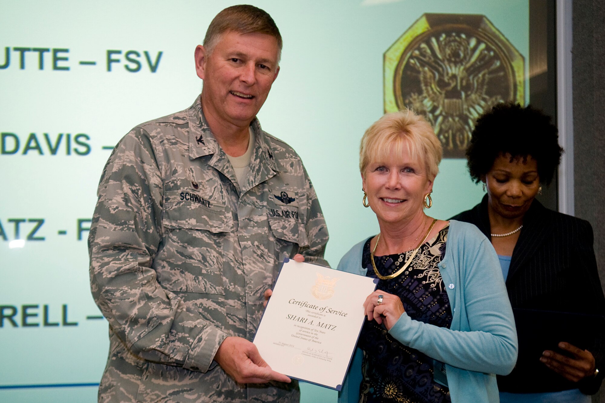 Col. Doug Schwartz, 434th Air Refueling Wing commander, presents Shari Matz, 434th Force Support Squadron, with a certificate of service for completing 10 years as a federal employee during a civilian commander's call at Grissom Air Reserve Base, Ind., Aug. 13, 2014. Civil service employees are an essential part Grissom and serve critical roles in maintaining unit readiness and daily operations. (U.S. Air Force photo/Tech. Sgt. Mark R. W. Orders-Woempner)
